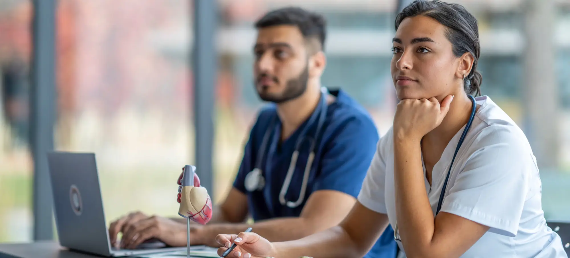 [Feature Image] After researching appropriate nursing degrees and certifications to advance their careers, learners attend a lecture as part of their studies. 