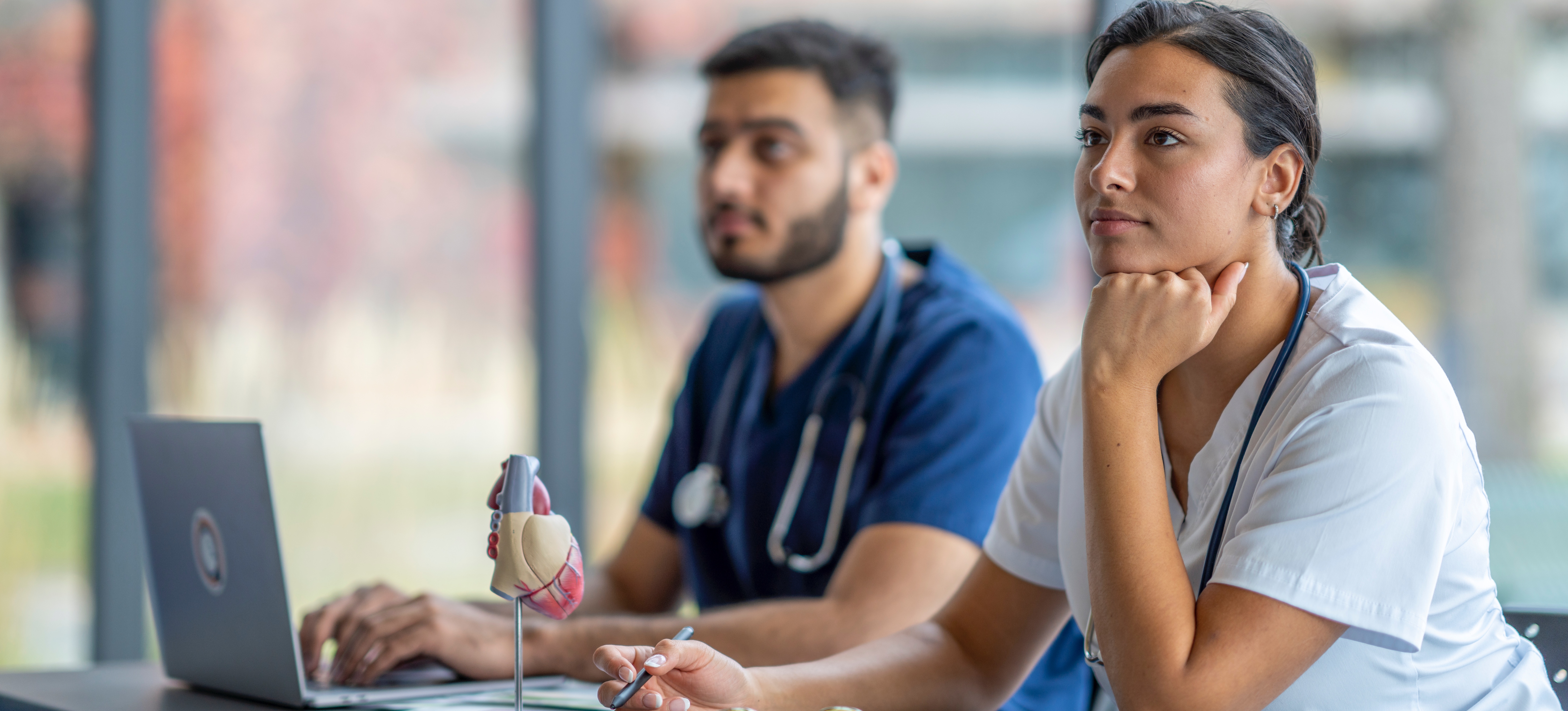 [Feature Image] After researching appropriate nursing degrees and certifications to advance their careers, learners attend a lecture as part of their studies. 