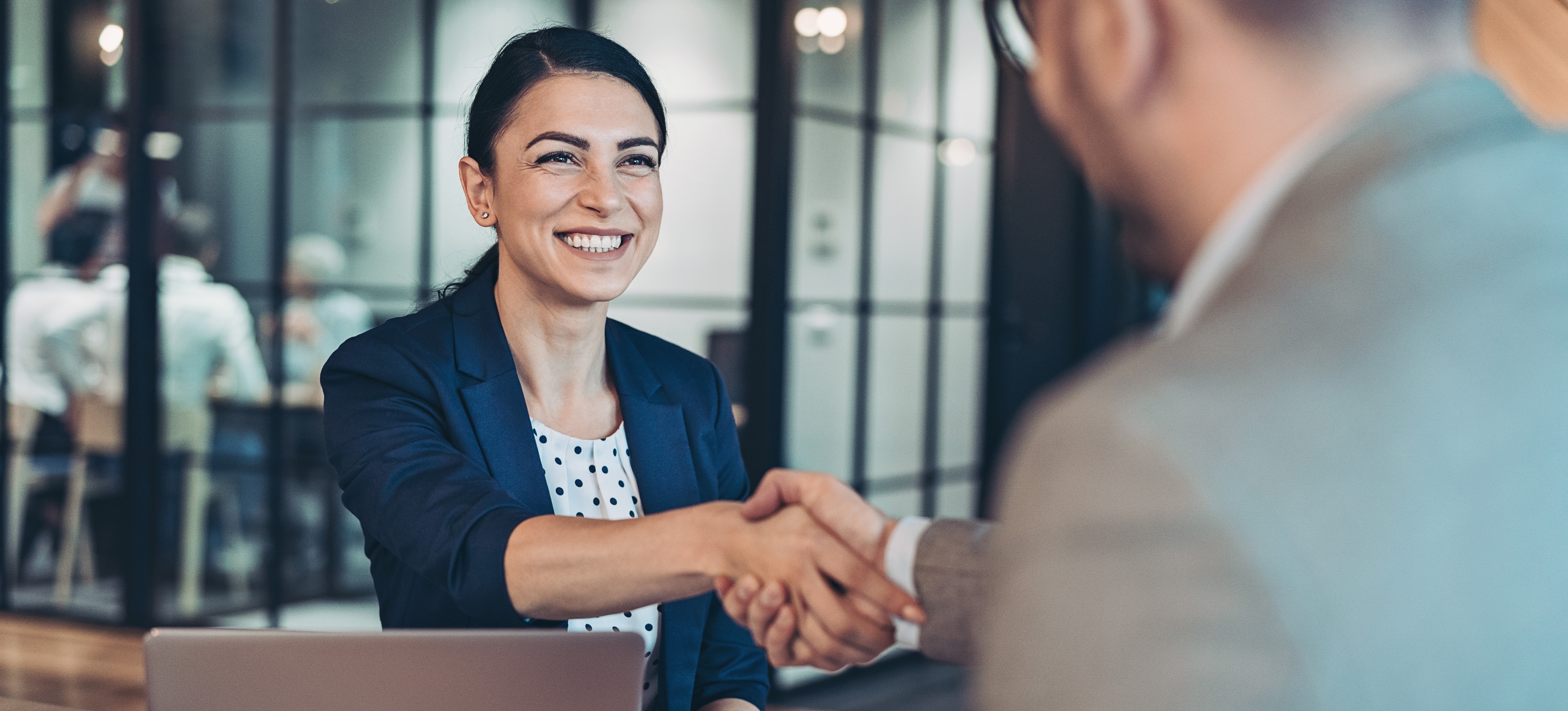 [Featured Image] An applicant meets with an interviewer, smiling and feeling confident after reviewing common software engineer interview questions to prepare.
