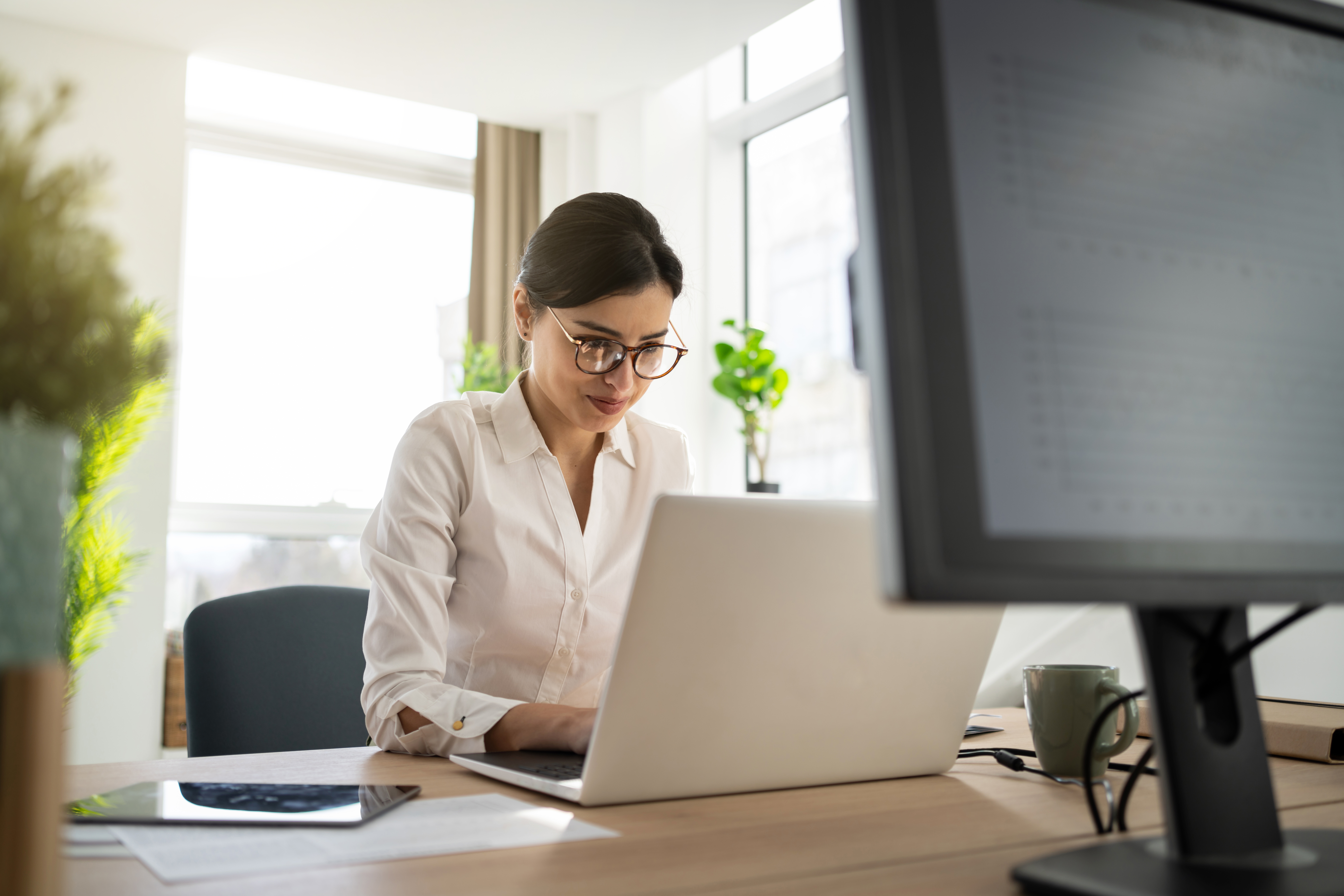 [Image en vedette] Une titulaire du certificat CBAP (Certified Business Analyst Professional) est assise dans son bureau et réfléchit tout en travaillant sur son ordinateur portable.
