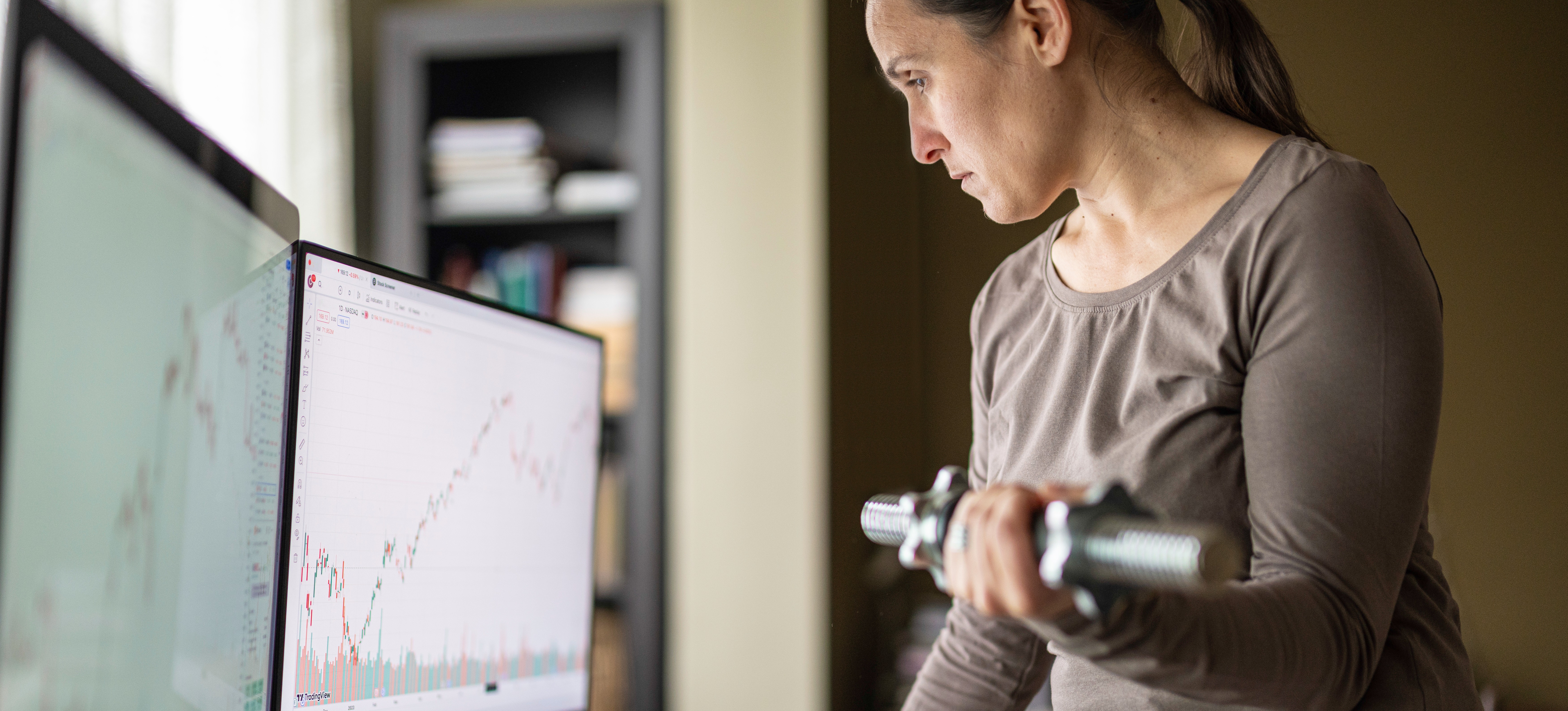 [Featured Image] A statistician stands at their desk viewing linear regression models on two computer monitors.
