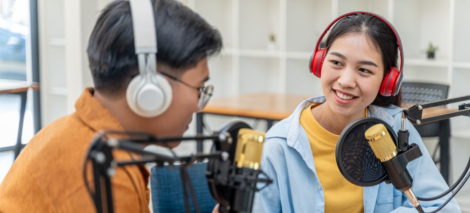 [Featured Image]: A man and woman record a podcast, an example of the various content creator jobs available.

