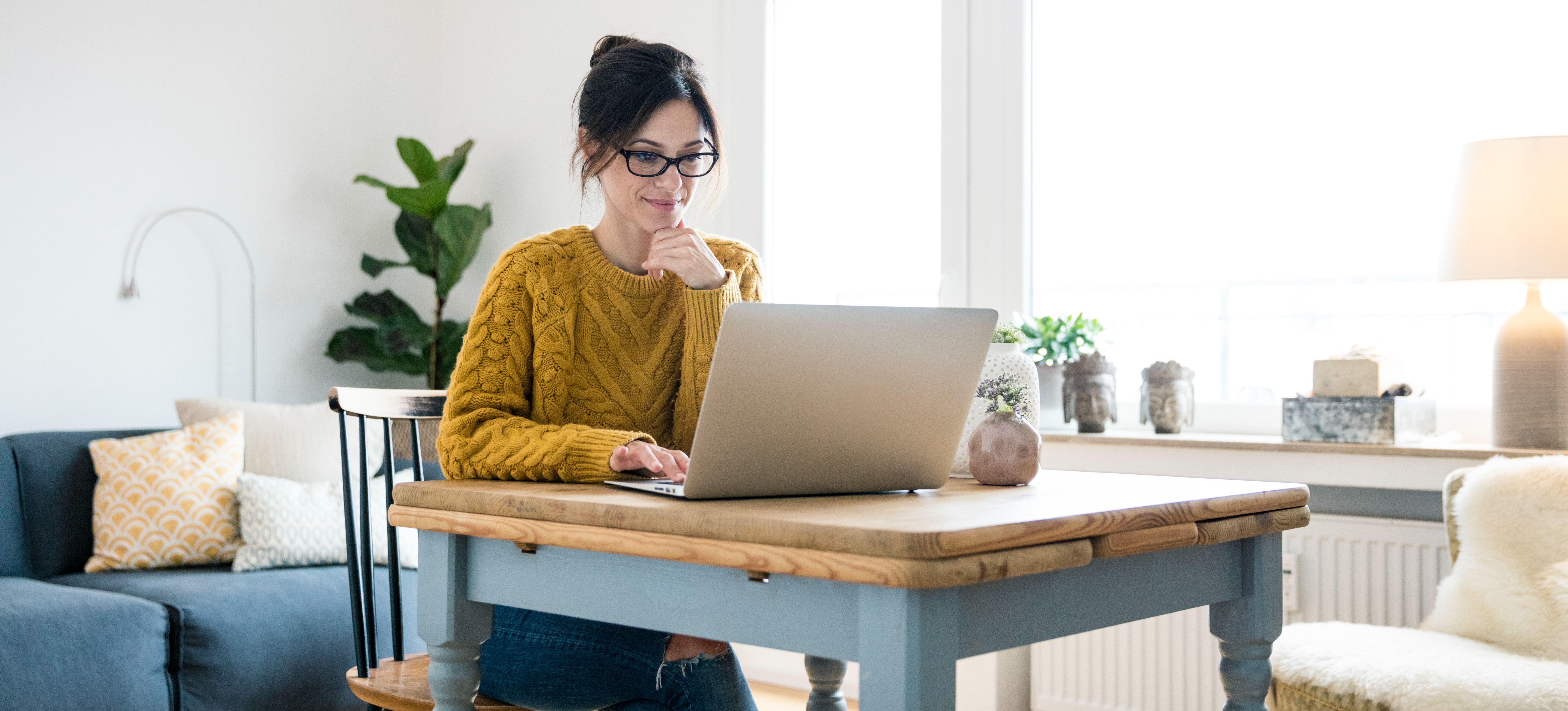 [Featured Image] A woman sits at a table and uses ChatGPT for students on her laptop.