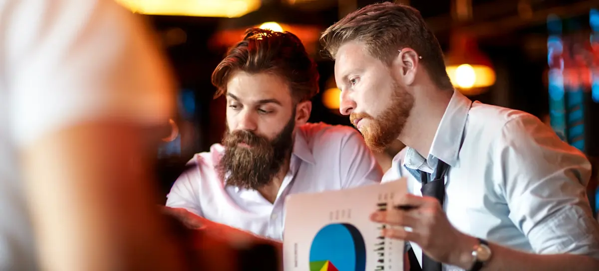 [Featured Image]: Two people review a cash flow analysis to evaluate the profitability of their business.
