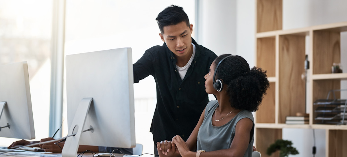 [Feature Image] Two learners share a deep discussion sparked by the question, “What does SQL stand for?” in a study area with desktop computers, wooden shelves, and windows with natural light.
