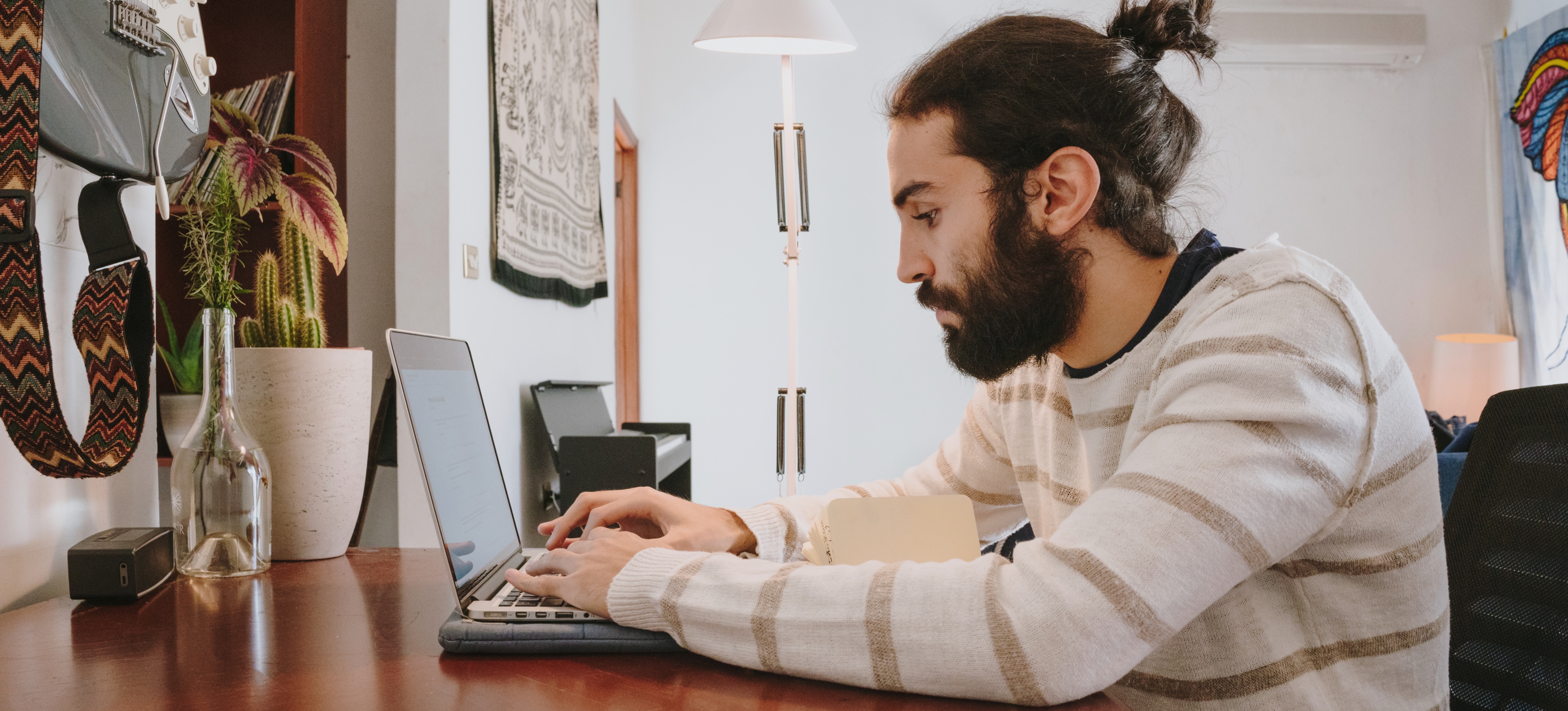 [Featured Image] An office worker in a white sweater sits at a desk with their laptop and searches about generative AI ethics.