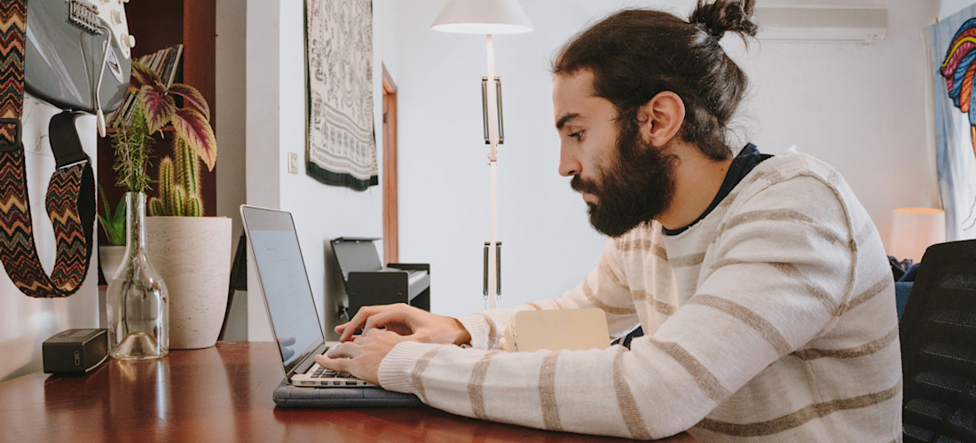 [Featured Image] An office worker in a white sweater sits at a desk with their laptop and searches about generative AI ethics.