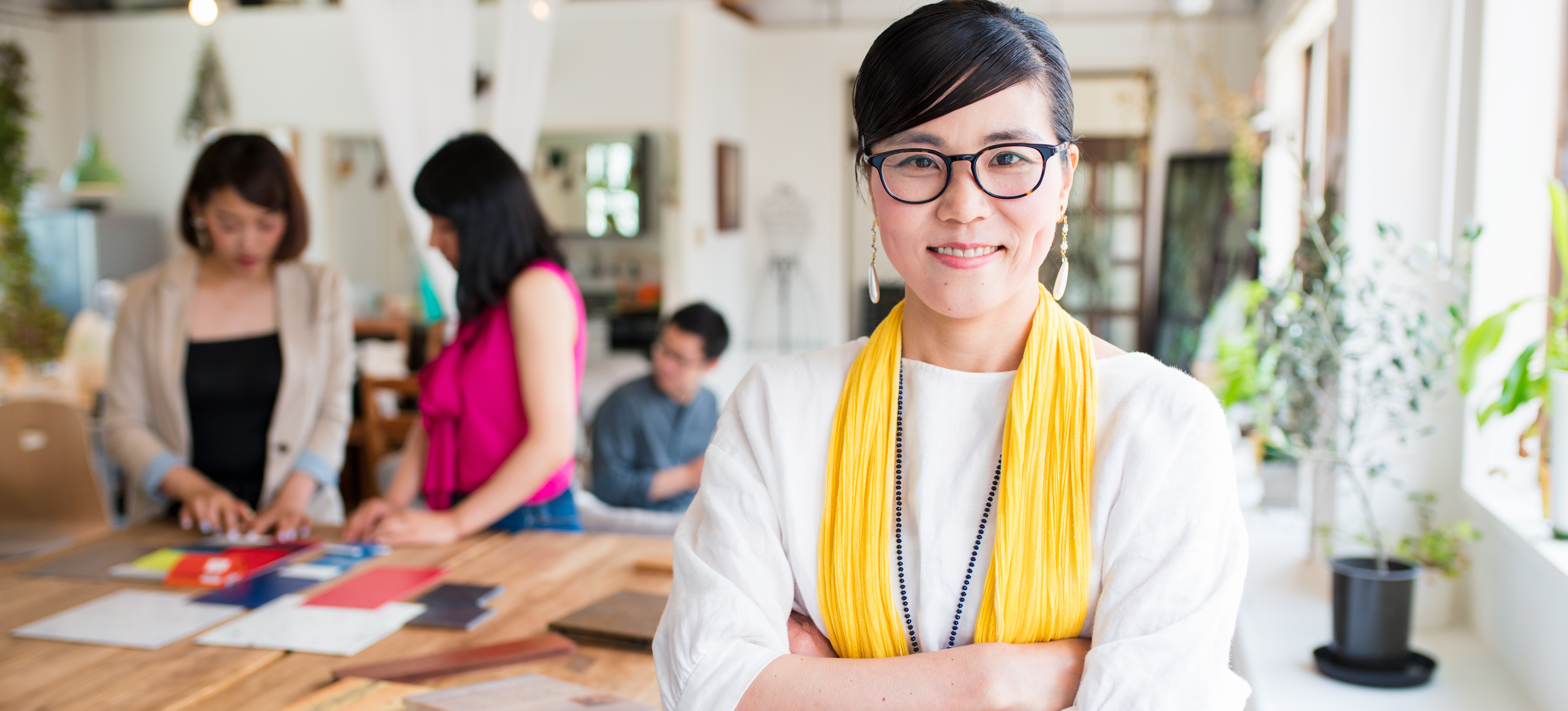 [Hauptbild] Ein Geschäftsinhaber steht in einem Großraumbüro.