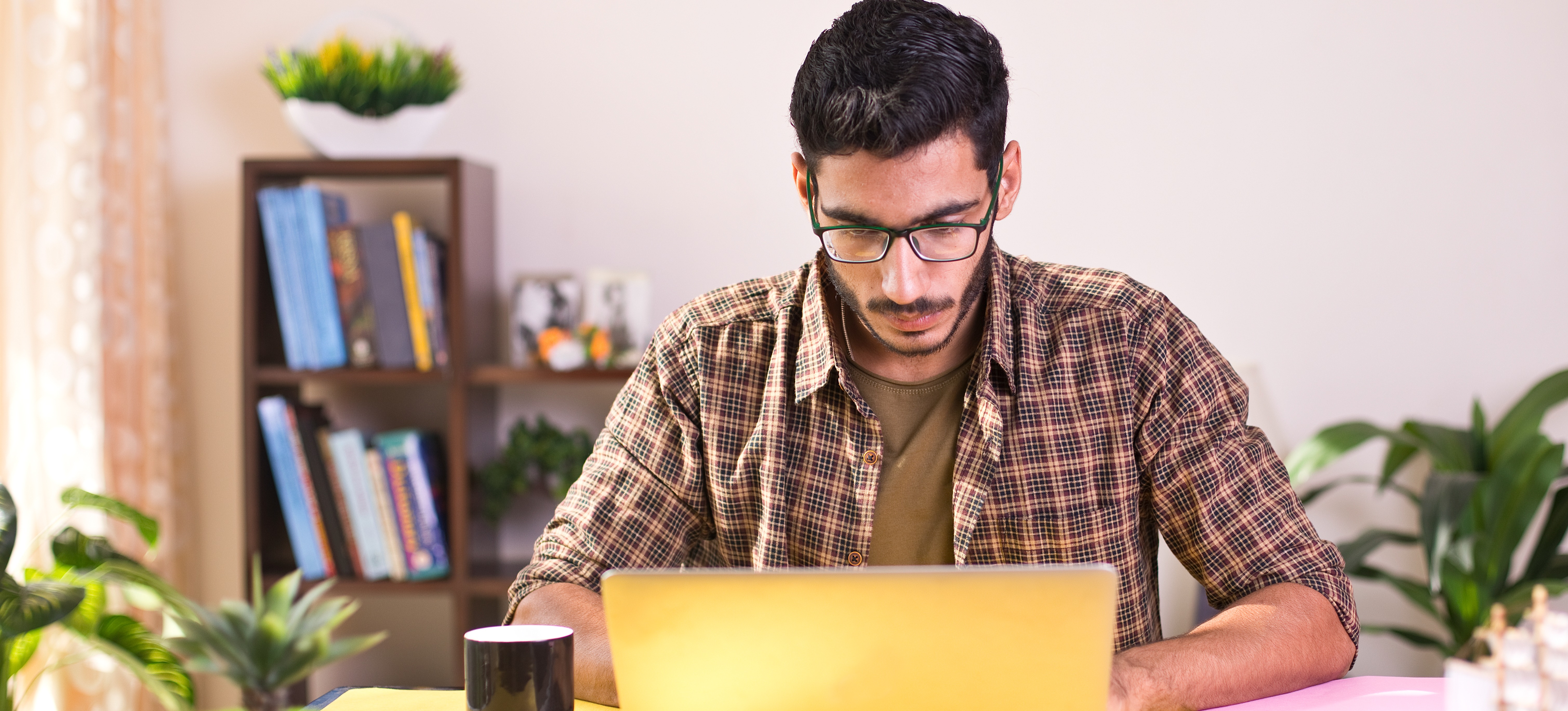 [Featured Image]: A web designer working on a laptop applies responsive web design principles while working on a project.
