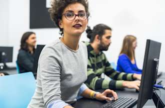 [Featured image] An aspiring software developer takes a programming class in a computer lab.