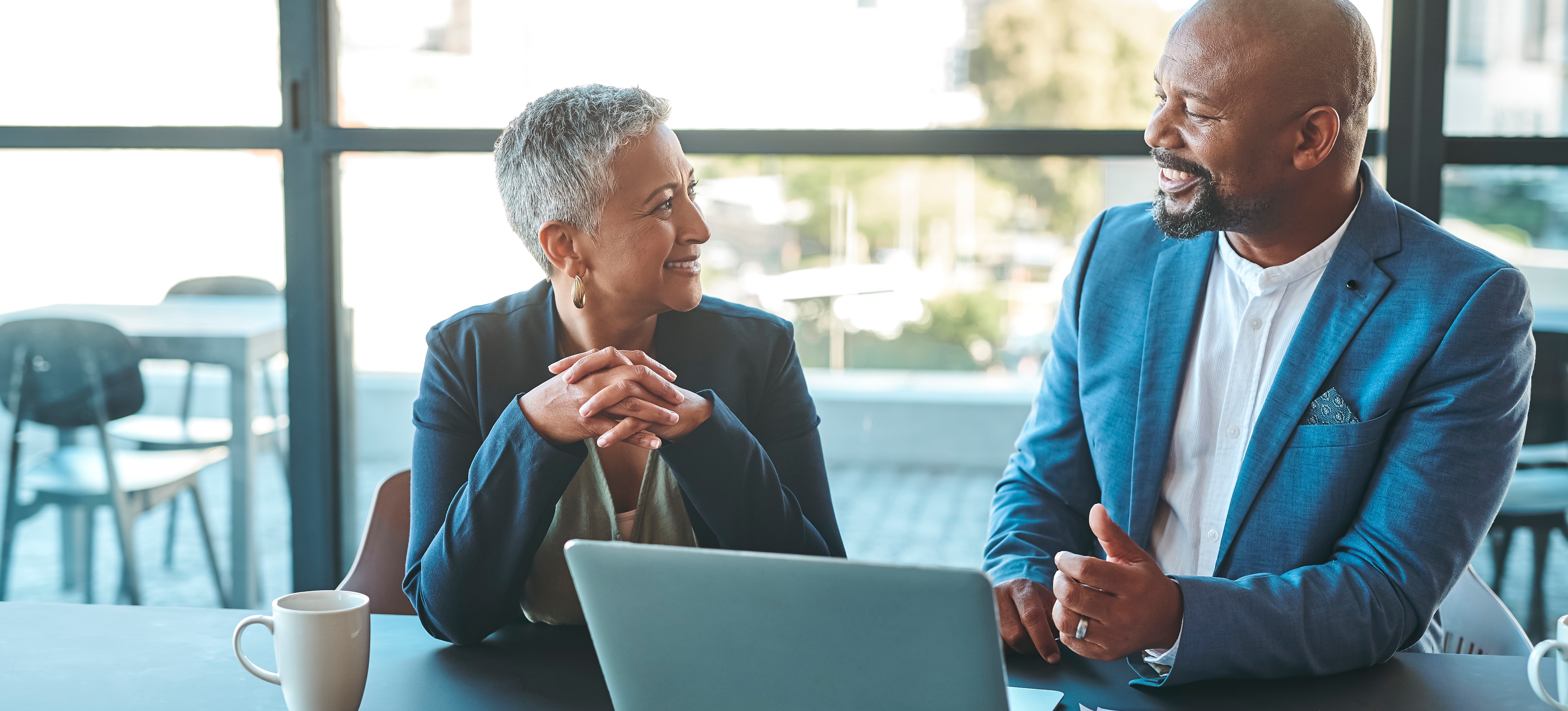 [Featured Image] A business development associate meets with senior leadership to discuss business strategies. 