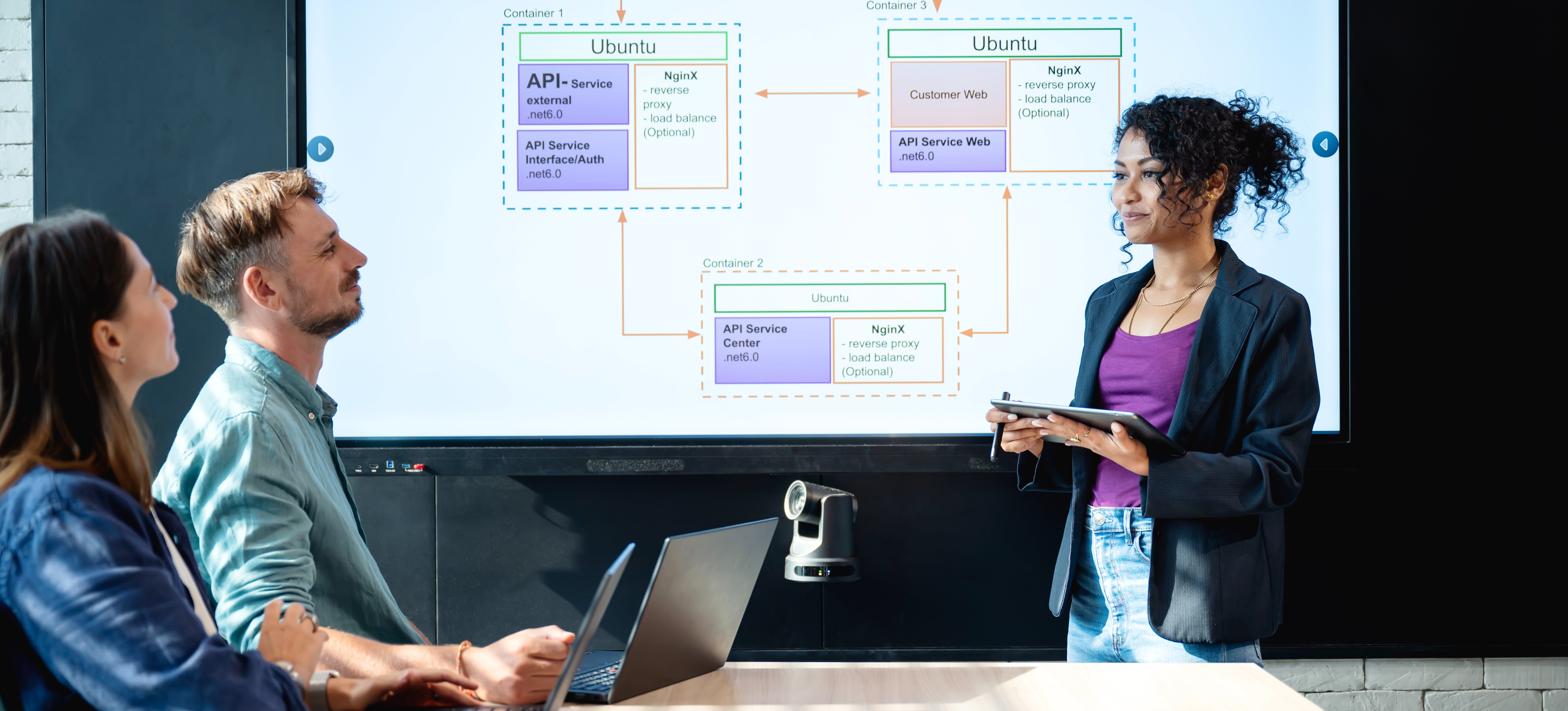 [Featured image]: Three team members demonstrate collaboration as they discuss a current project, demonstrating a key principle in the topic of Scrum versus Six Sigma.