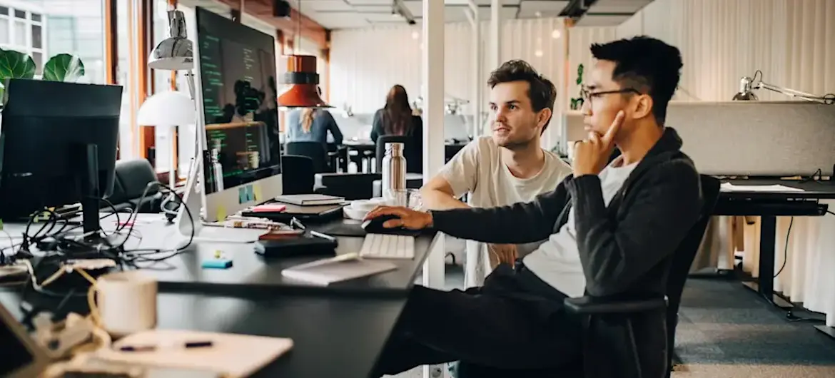 [Featured Image] Two software developers are using the design pattern mvvm during a project.