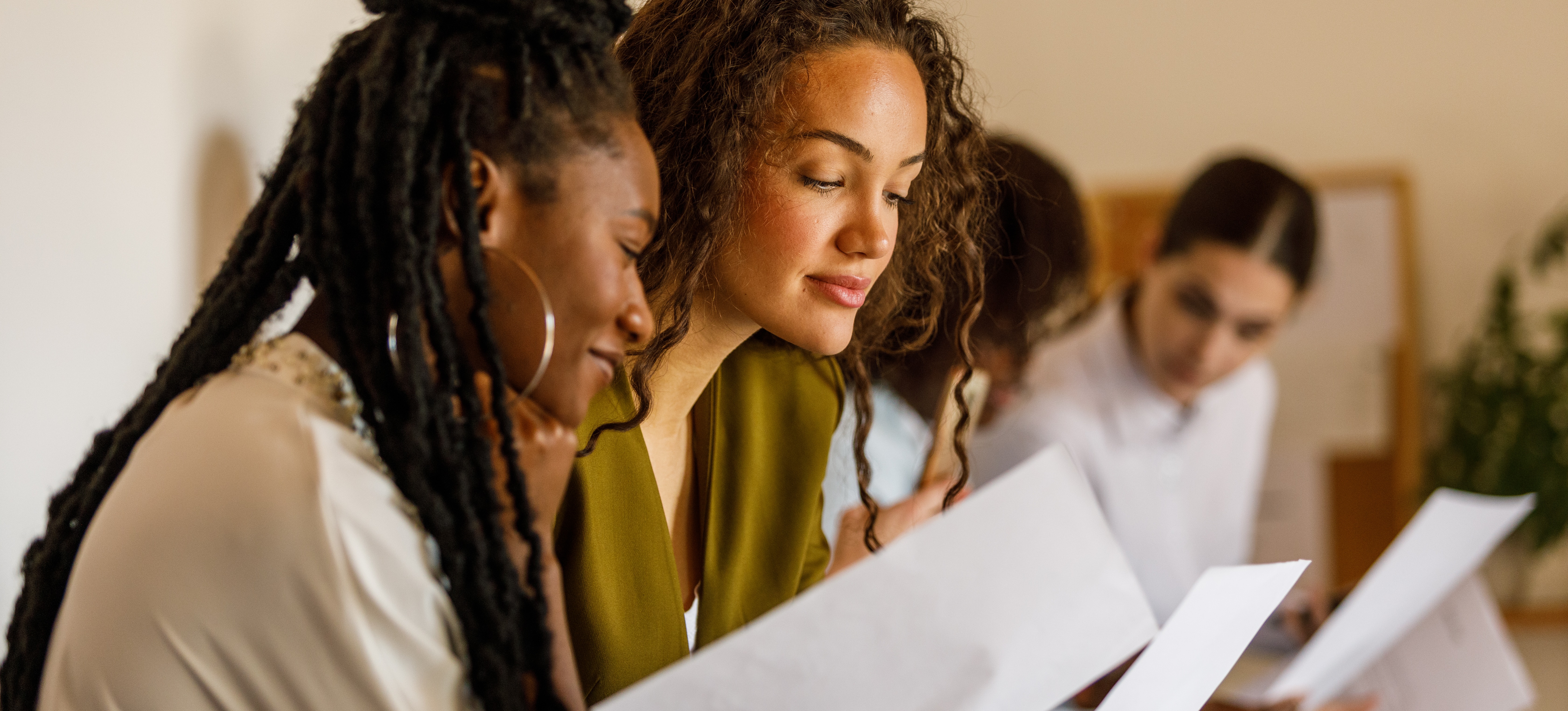 [Featured Image] Job applicants review their graphic design CVs whilst waiting for their interviews. 
