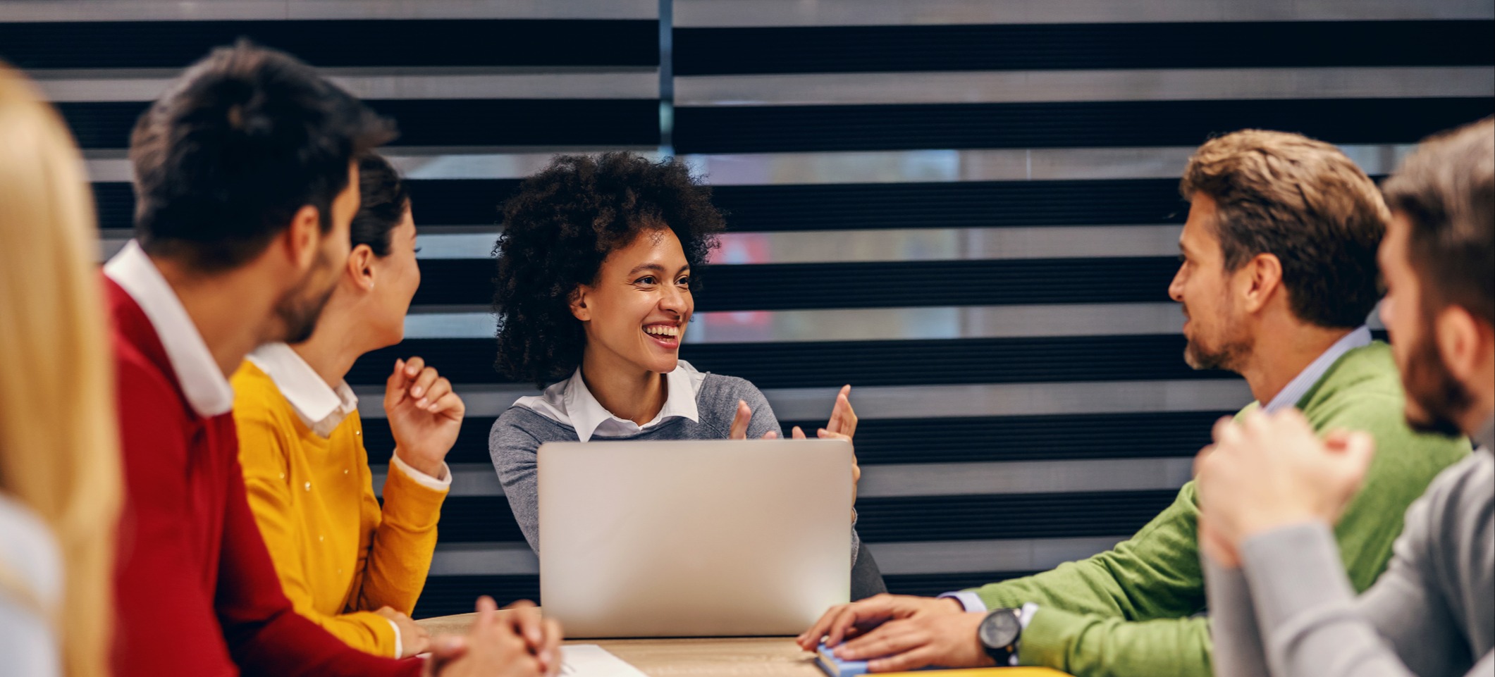 [Featured Image] A sales development representative meets with a team in a conference room.