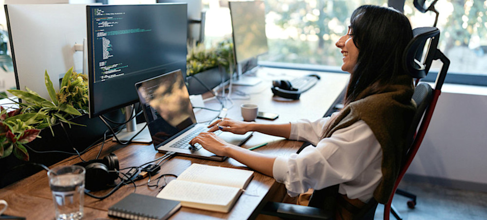 [Featured Image] A professional in a modern workspace focused on coding in C# on their computer.