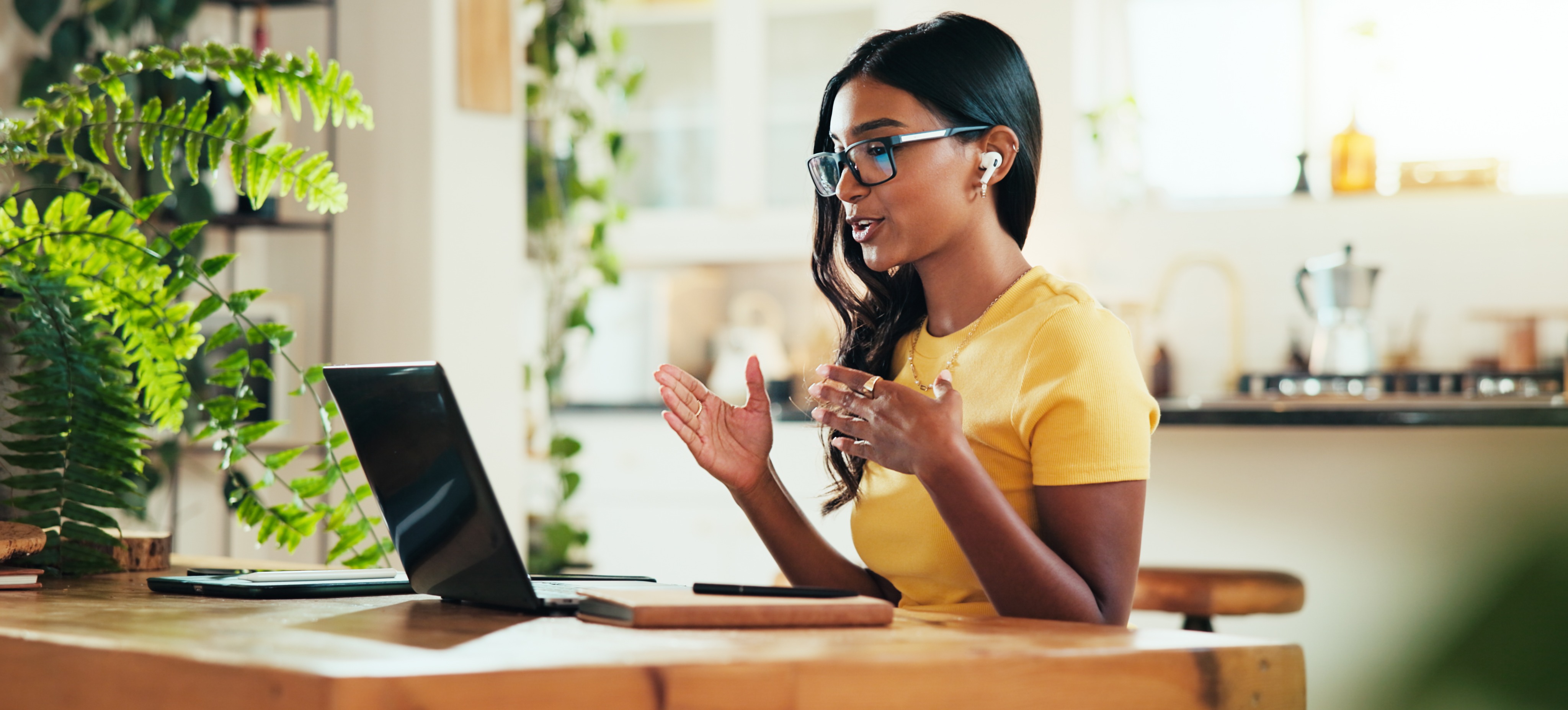 [Featured Image] An entrepreneur sits at a table, recording an online class to help earn passive income.
