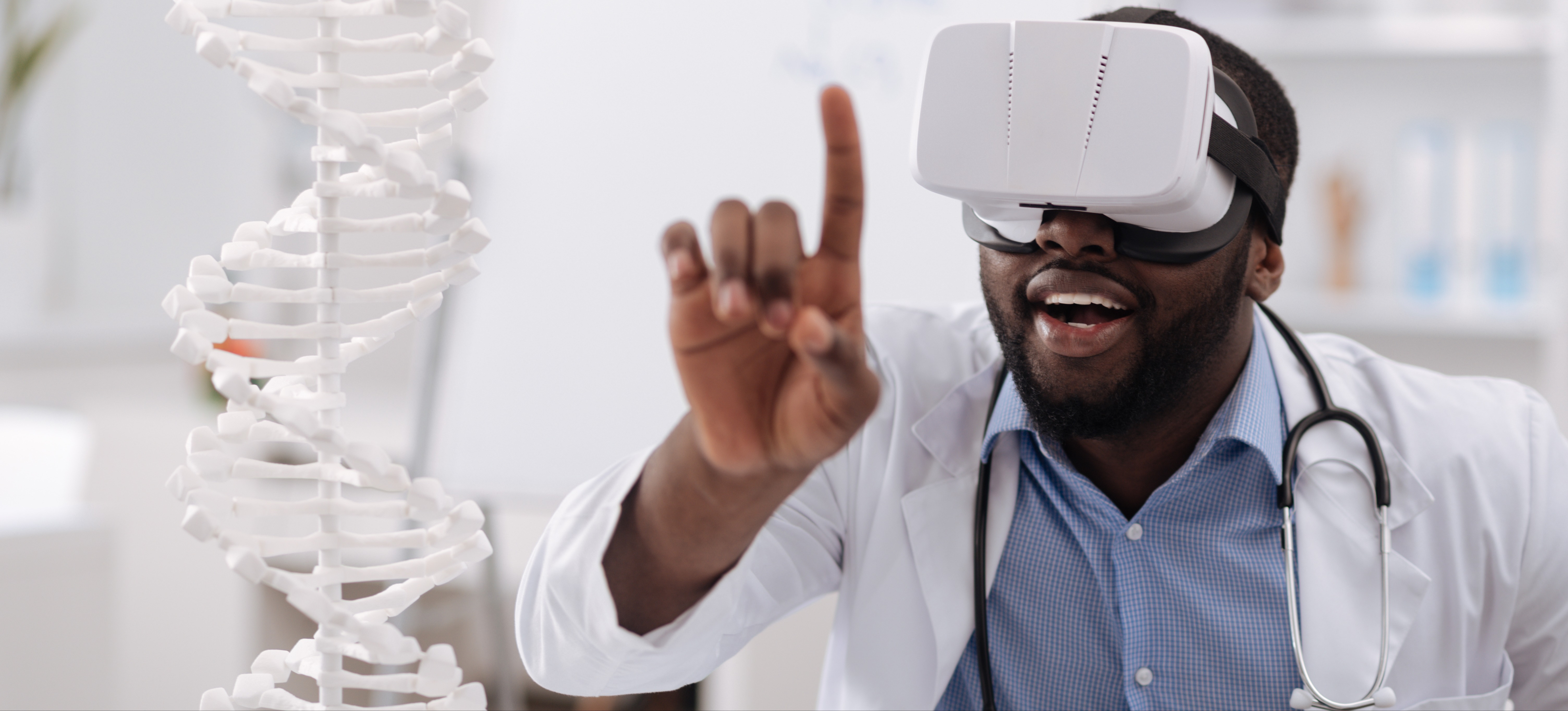 [Featured Image] A physician wearing augmented reality glasses, a white lab coat, and a stethoscope studies a DNA model.
