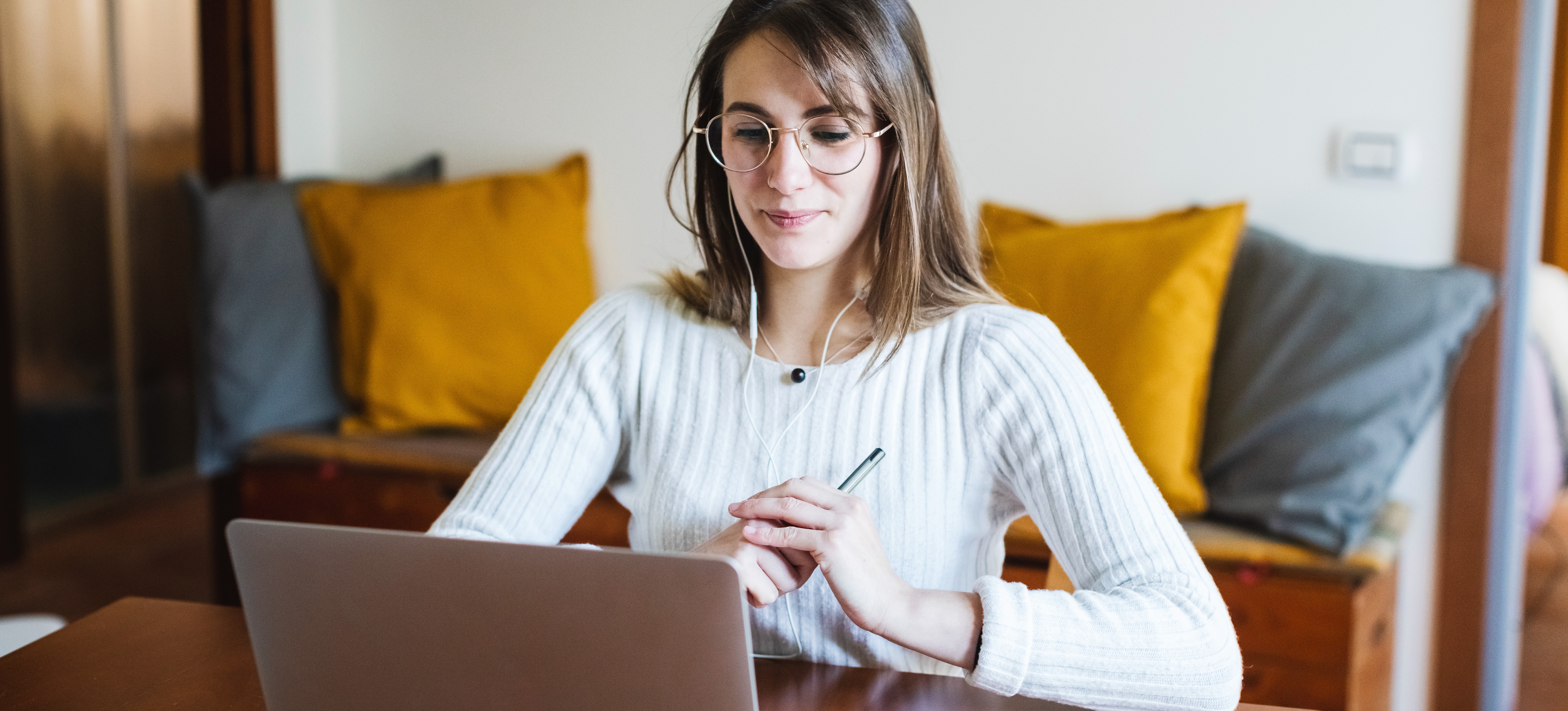 [Featured image] A person in a white shirt and headphones sits at a laptop working on their grad school resume.