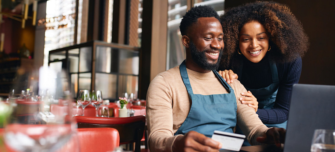 [Image en vedette] Deux entrepreneurs sont assis dans leur magasin et discutent des quatre P du marketing en regardant l'écran d'un ordinateur portable.