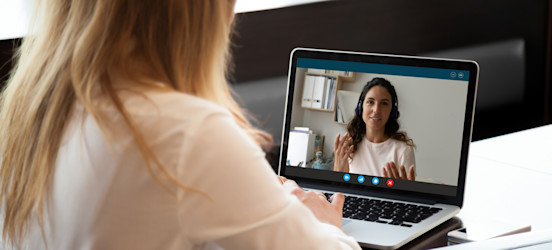  [Hauptbild] Zwei Frauen führen einen Videoanruf mit einem Computer im Vollduplex-Modus, während beide Computer Informationen senden und empfangen.
