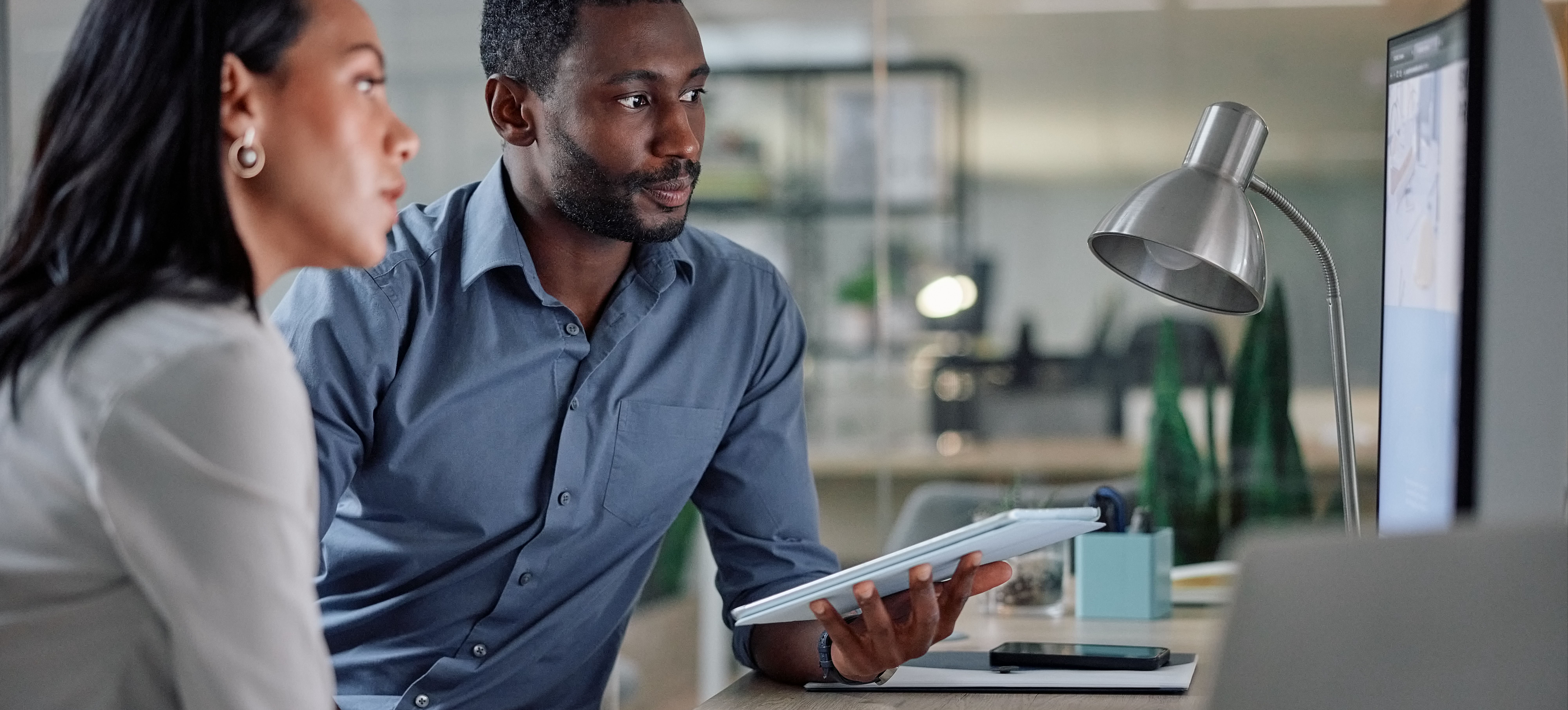 [Featured Image] Two learners study for their professional development course, learning about AI versus algorithms.
