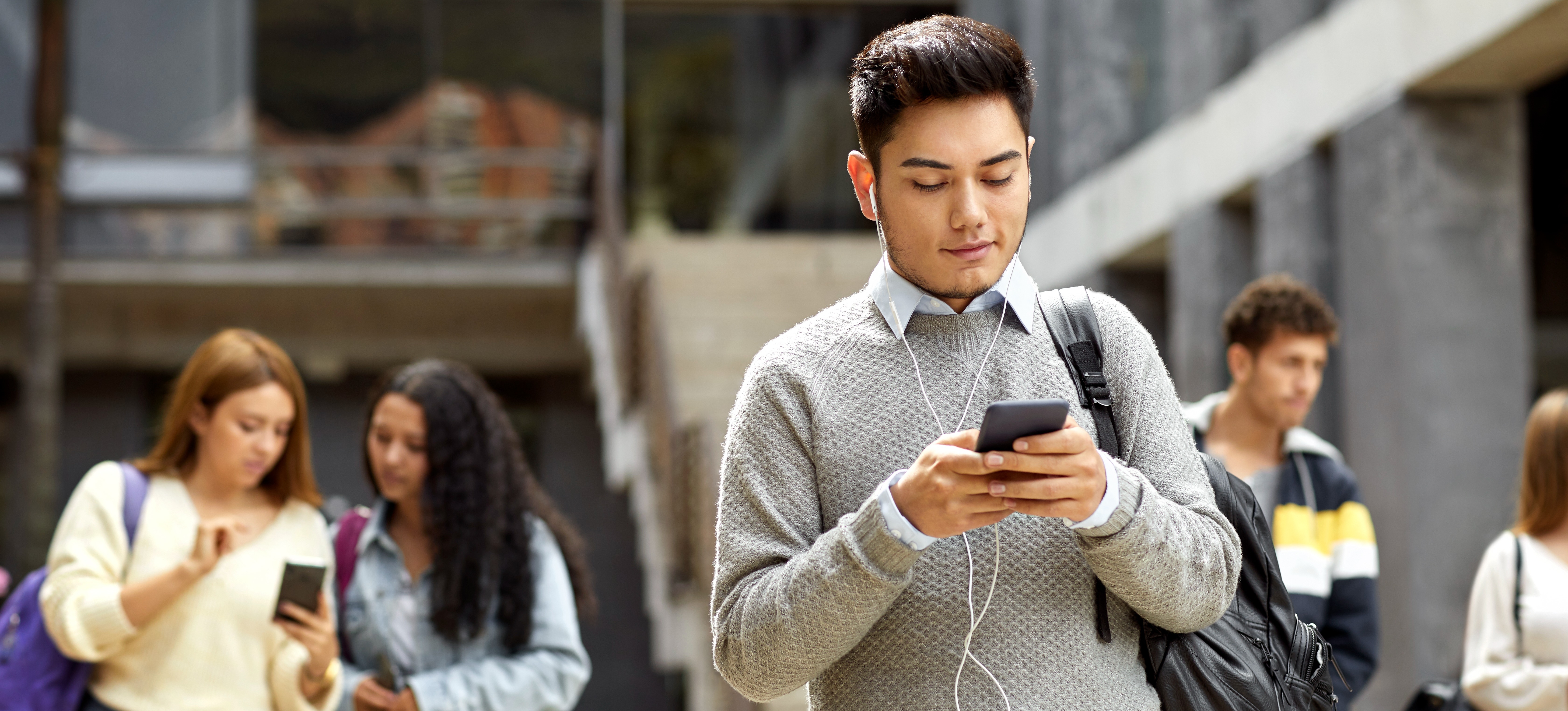 [Hauptbild] Eine Person nutzt Microlearning auf ihrem Mobilgerät, während sie draußen spazieren geht.