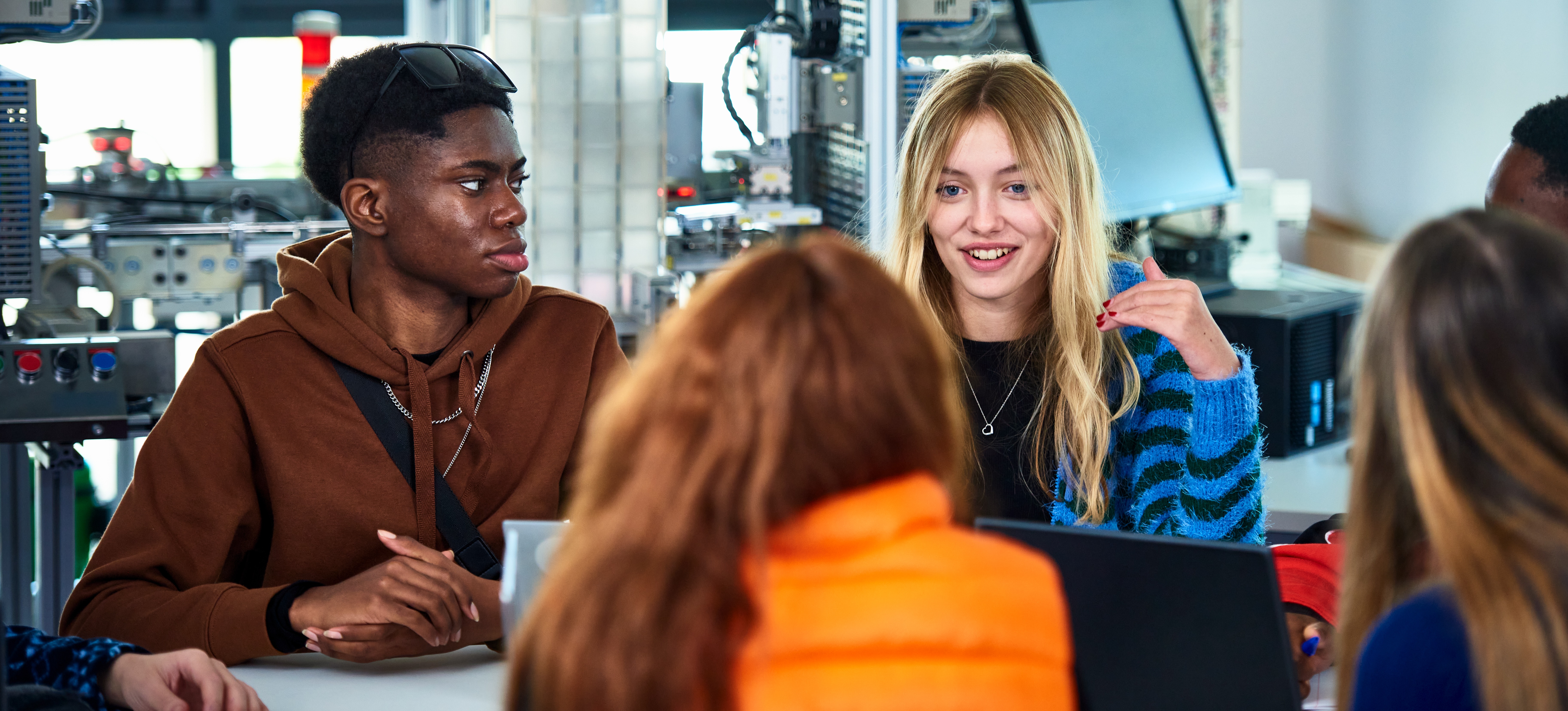 [Featured Image] Student in a programming class are learning the difference between devops and software engineers.