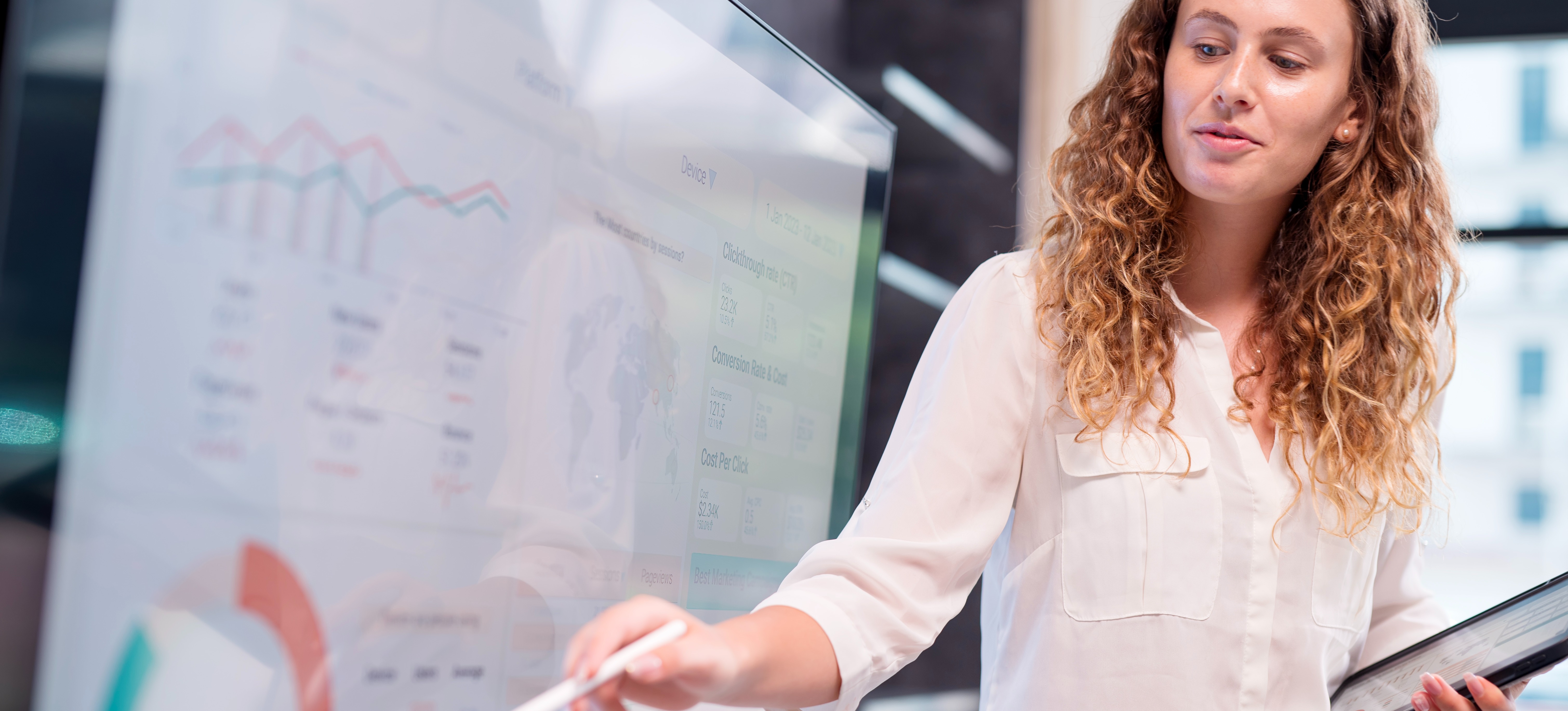 [Featured Image] After attending a data analytics boot camp, a data analyst feels more confident as she presents to her colleagues, pointing to a screen filled with graphs and charts.
