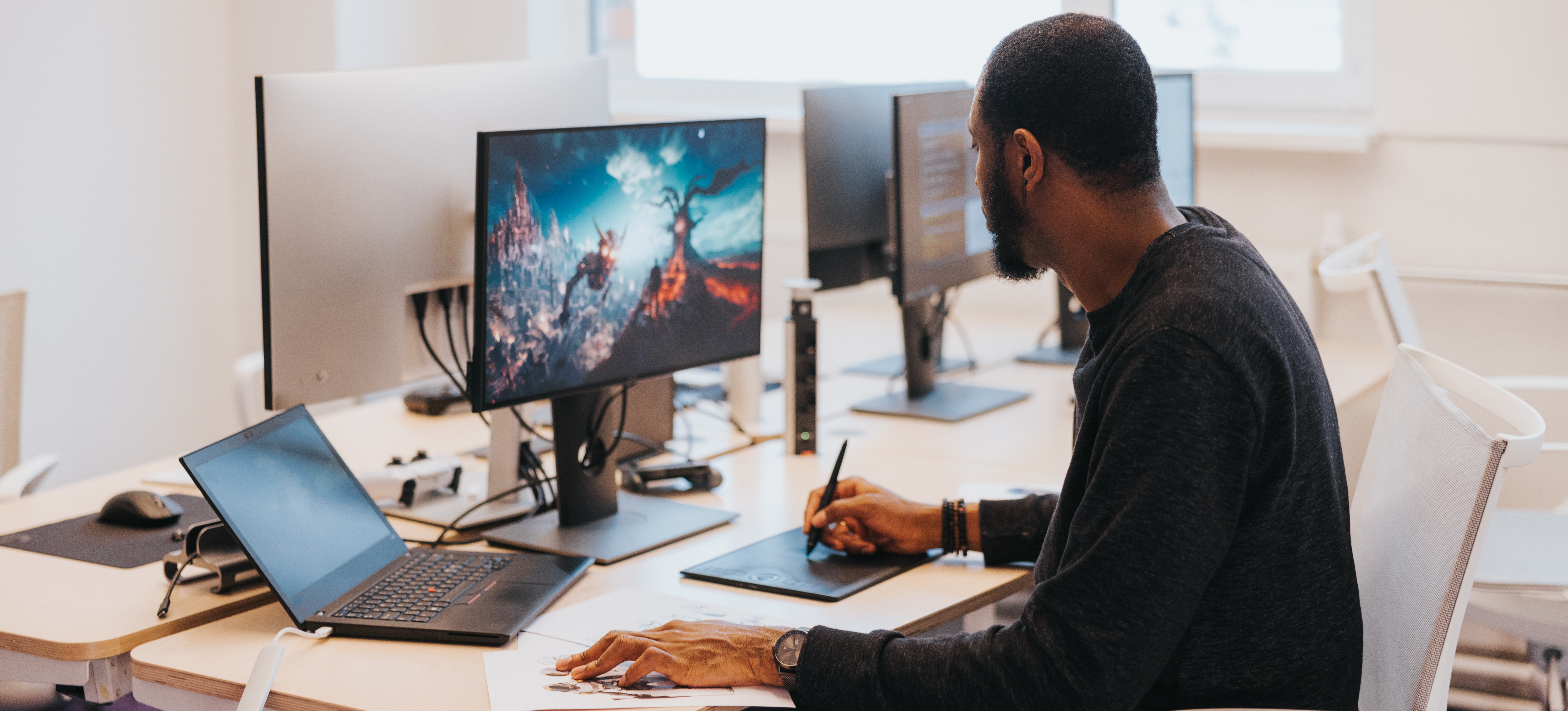 [Feature Image] A video game developer uses software and design tools to create a new game.
