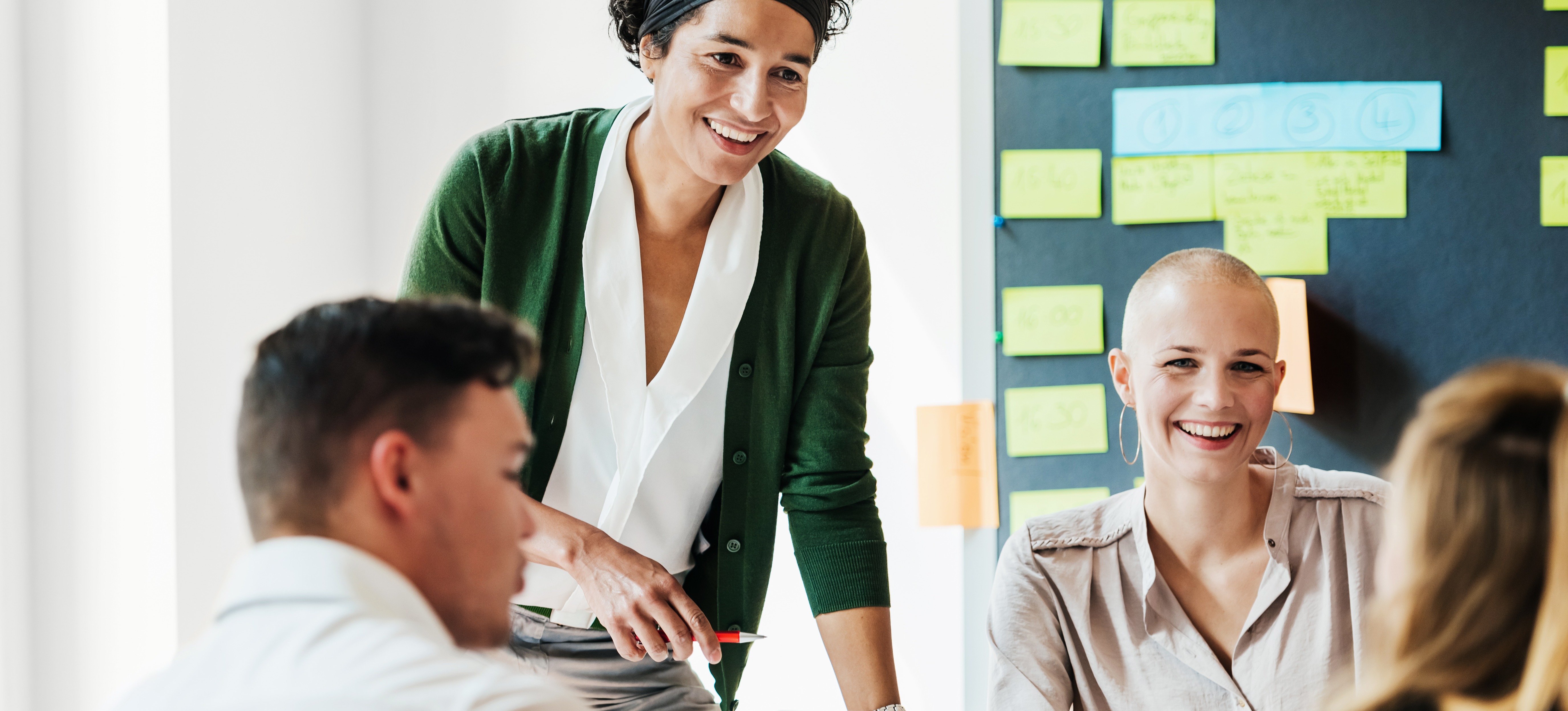 [Featured Image] A group of employees meet in their office to discuss the digital transformation of their customer experience. 
