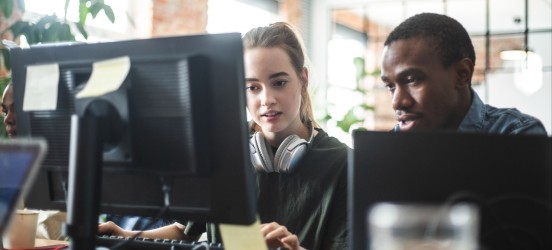[Featured image] Man and woman working on a digital marketing plan at computer