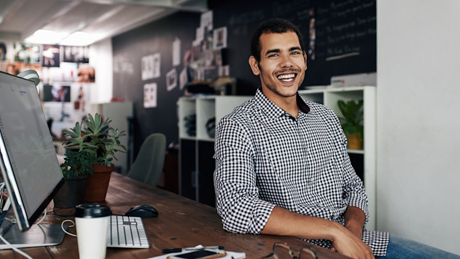 [Featured image] A social media manager sits at a desk with a desktop computer.