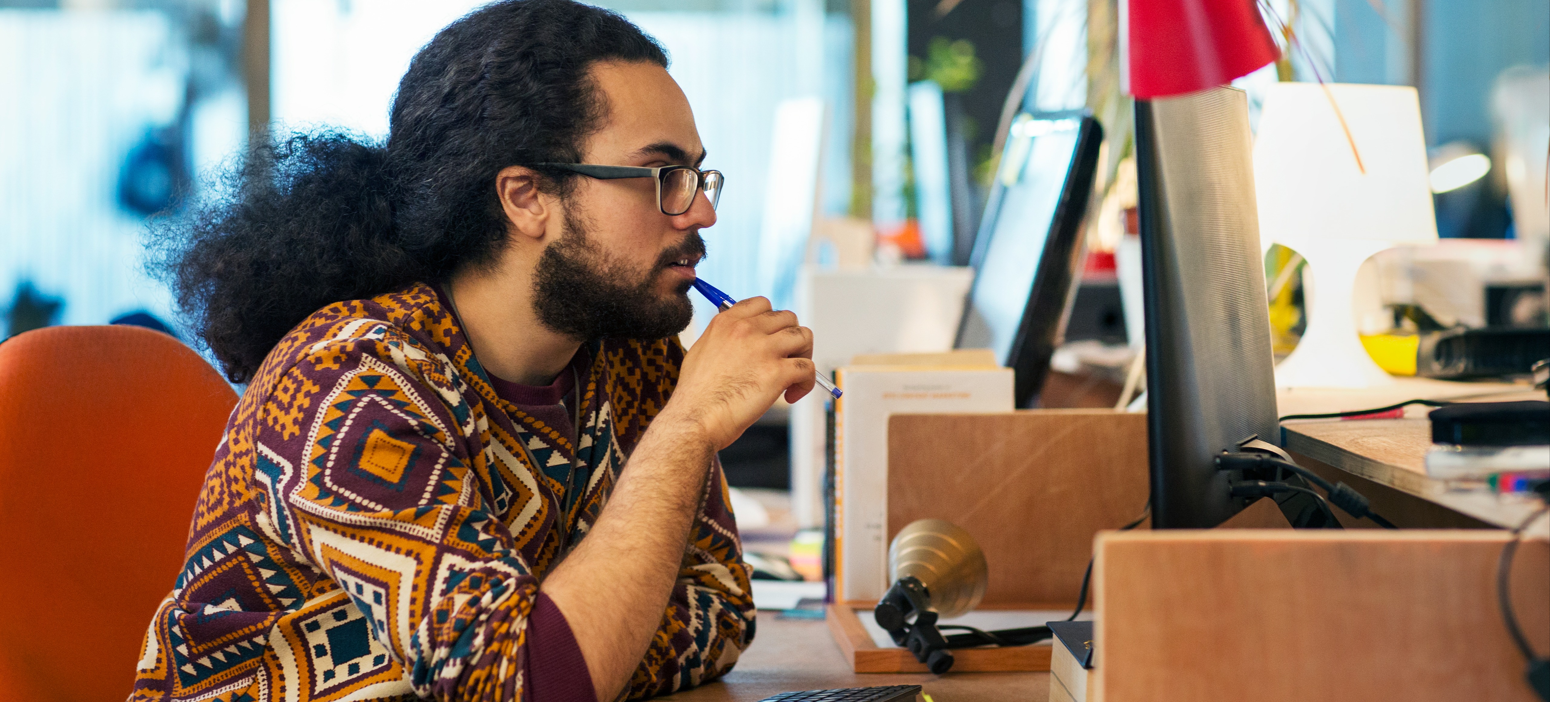 [Featured Image] A UX designer works at a computer, using interactive prototyping.
