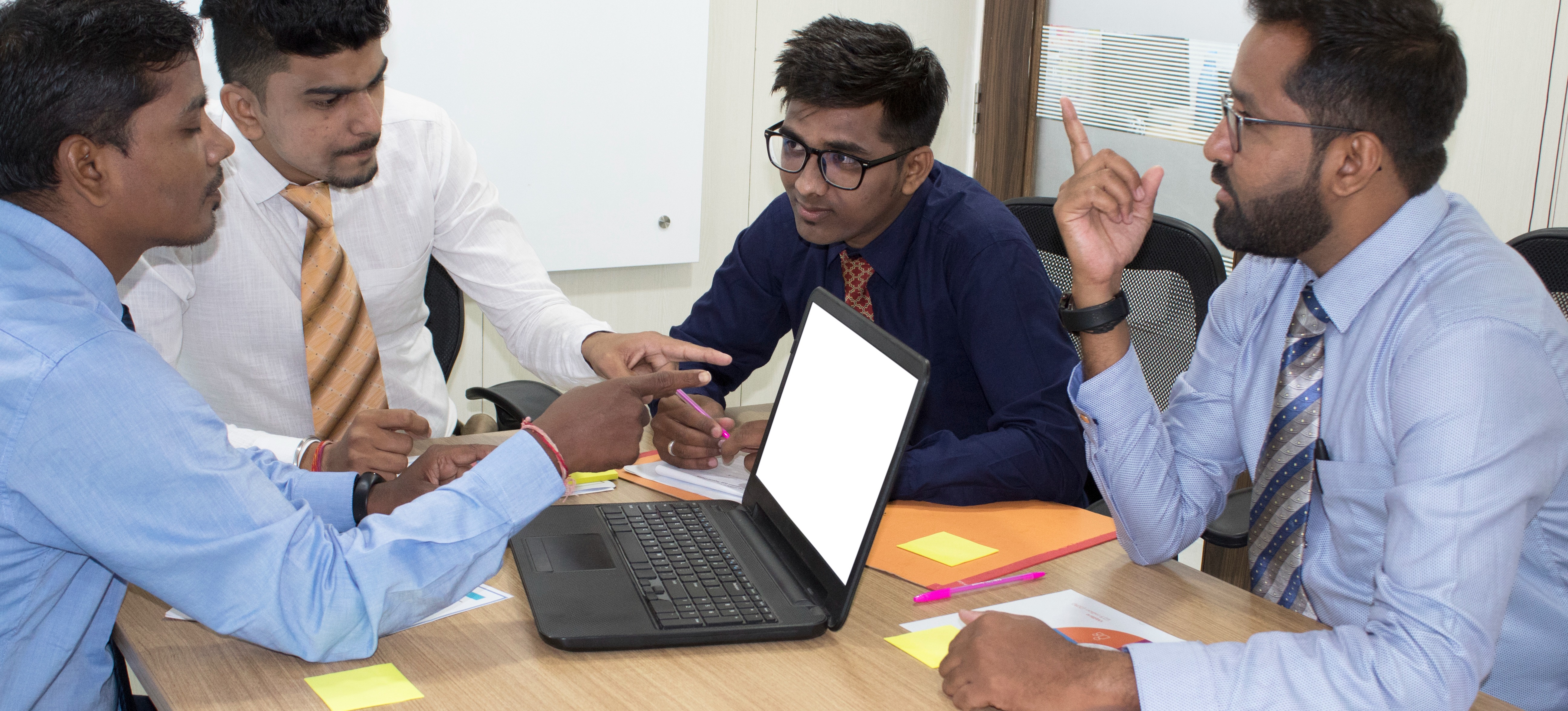 [Featured Image]:  Agile Project Manager, wearing a plaid shirt, is analyzing information with members of the team. 