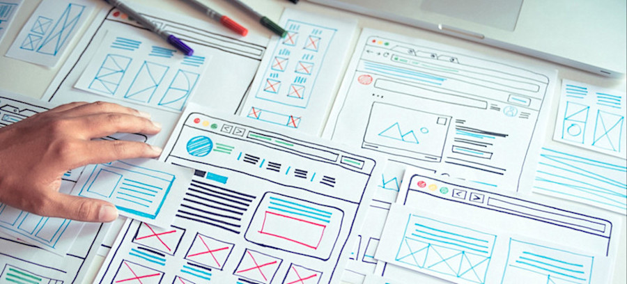 [Featured Image] A react developer sketches ideas for the user interface of a web application. 

