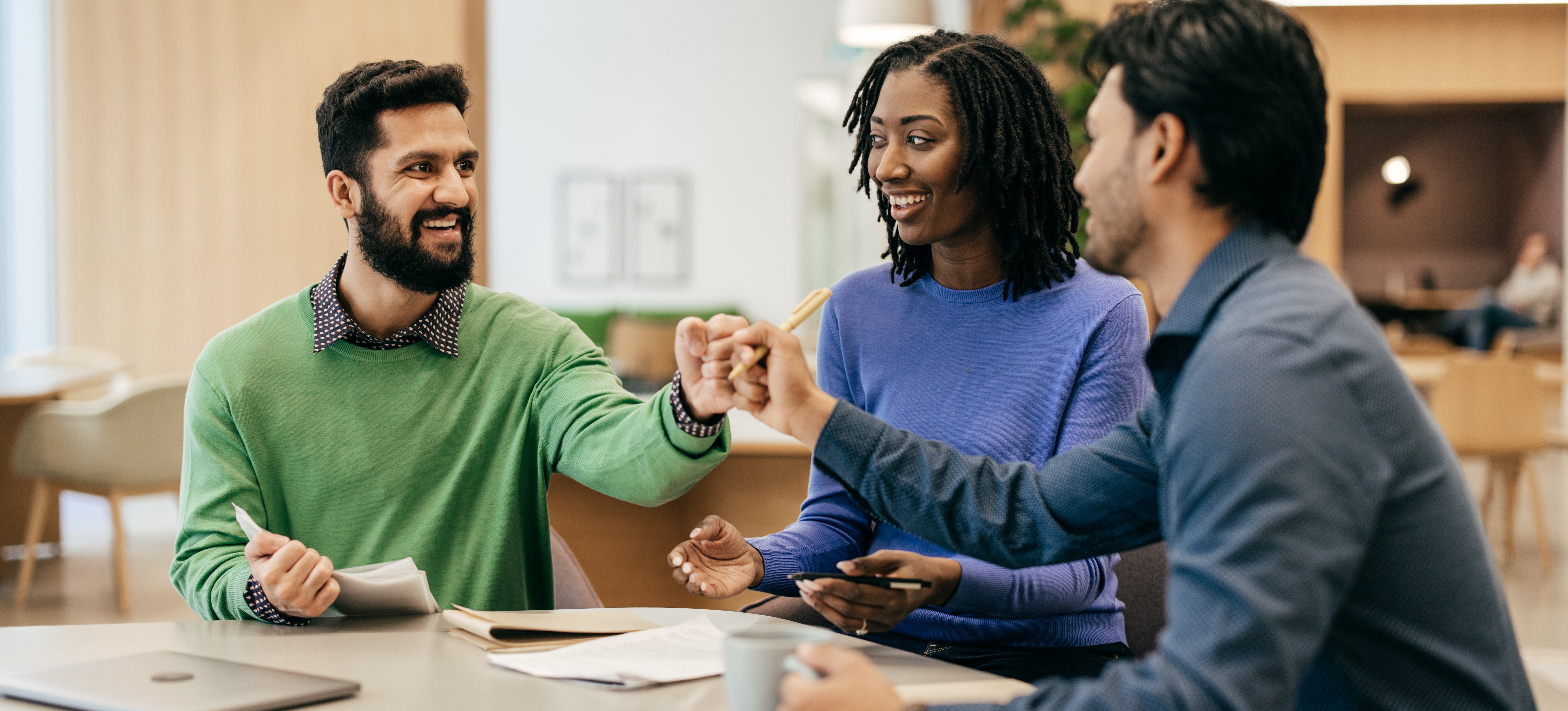[Featured Image] A trio of learners excitedly research data analyst career paths whilst figuring out their goals. 
