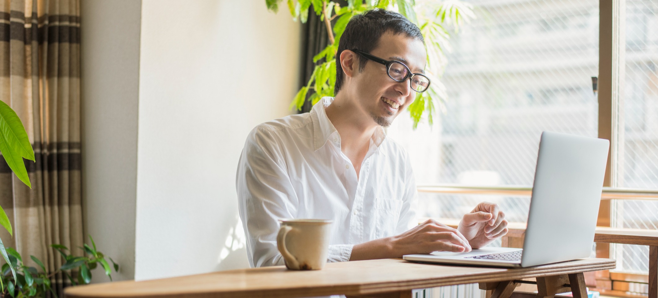 [Image en vedette] Un homme travaille à un bureau sur un ordinateur portable.