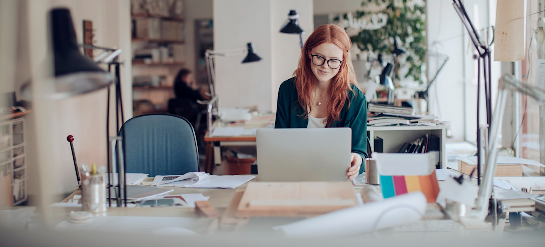 [Featured Image] A person in glasses searches online for entry-level graphic design jobs on a laptop.