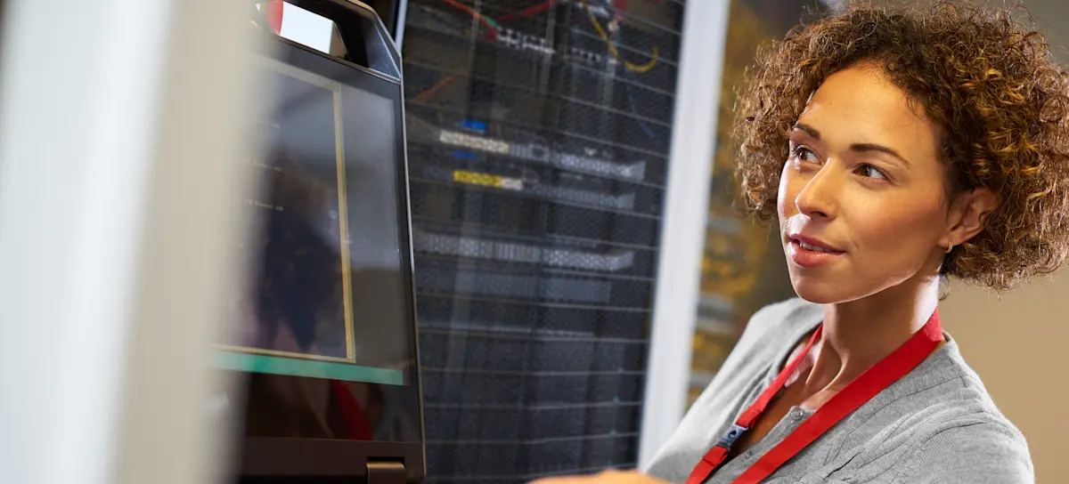 [Featured Image] A computer networking professional is editing a program on the network server with edge computing.
