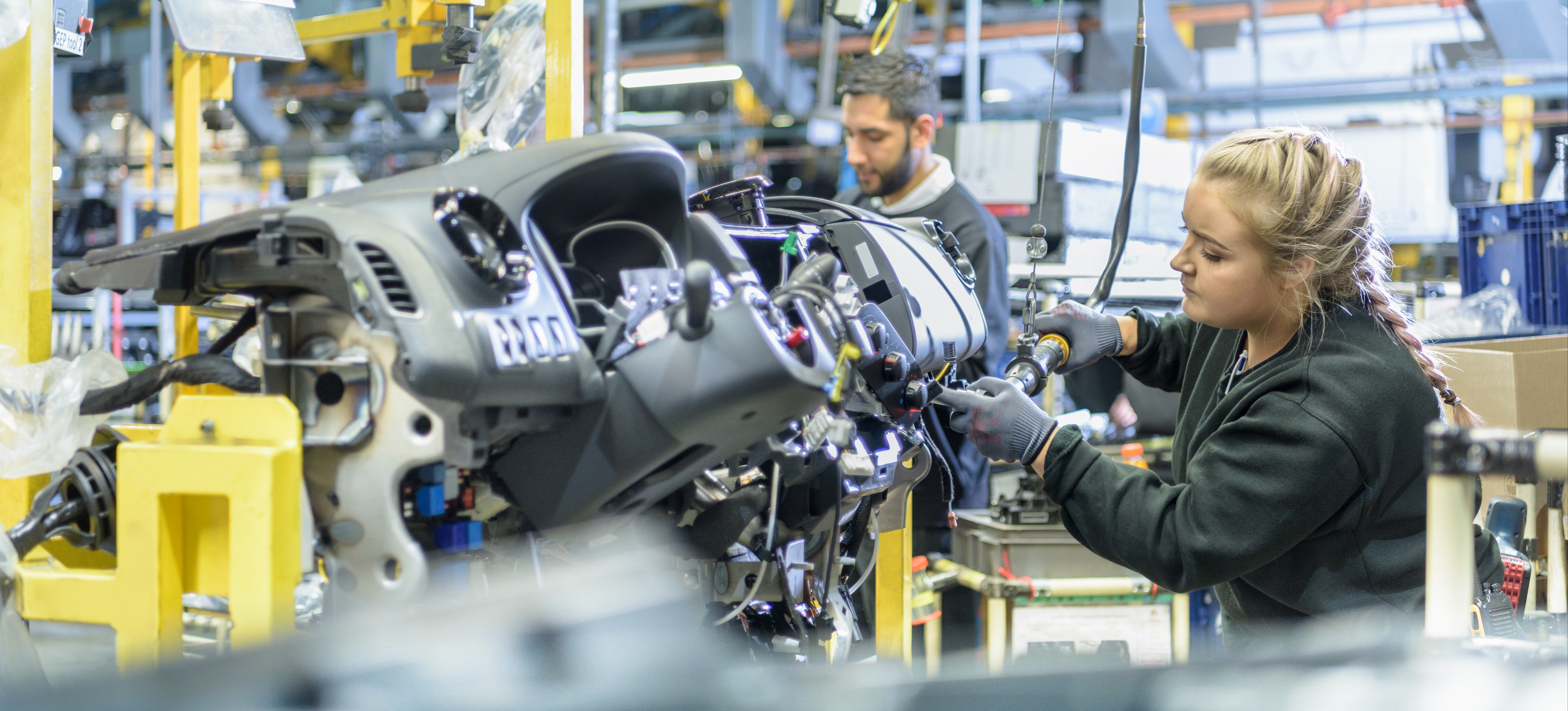 [Featured Image] An engineering apprentice is working on a car, earning qualifications on her chosen vocation.