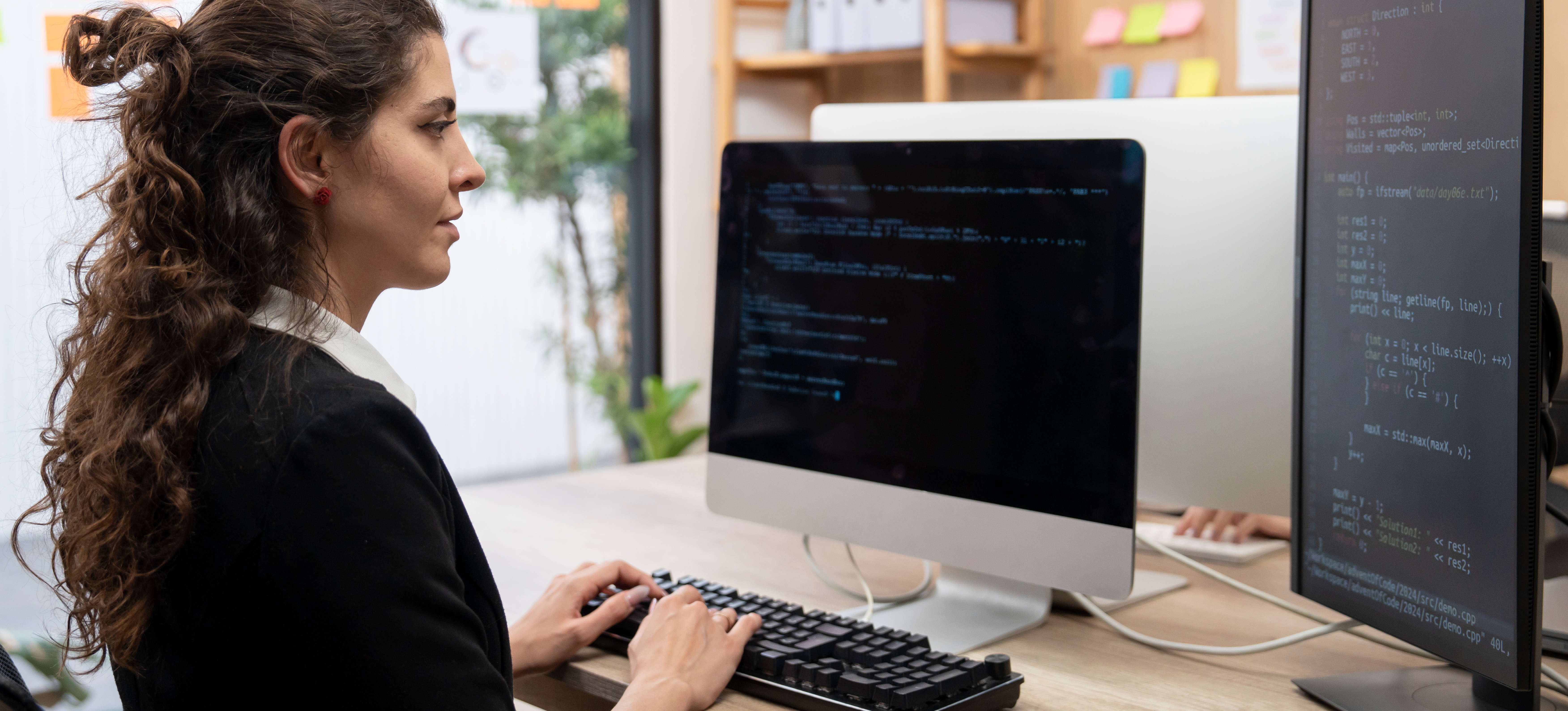 [Featured Image] A C# developer is at her desk developing an application for her company.