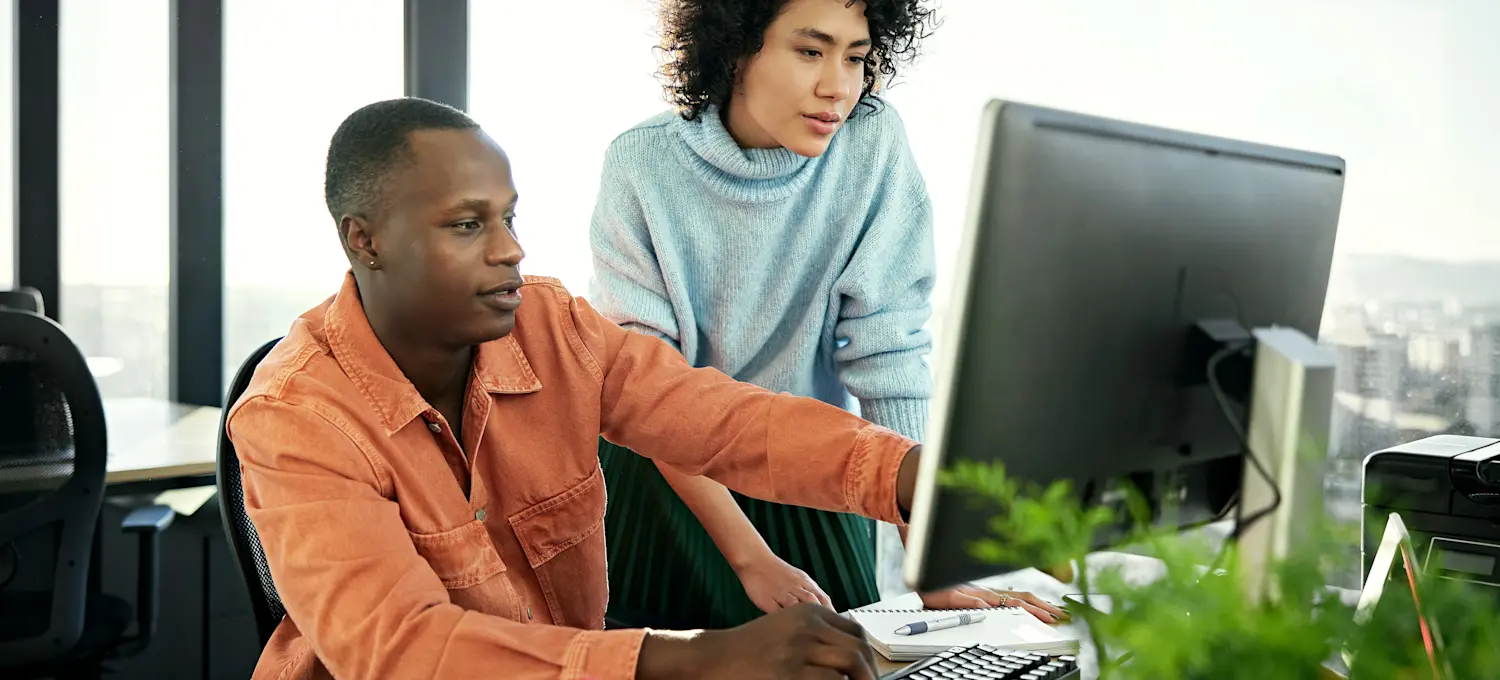 [Featured Image] A computer scientist collaborates with a colleague in an office setting.
