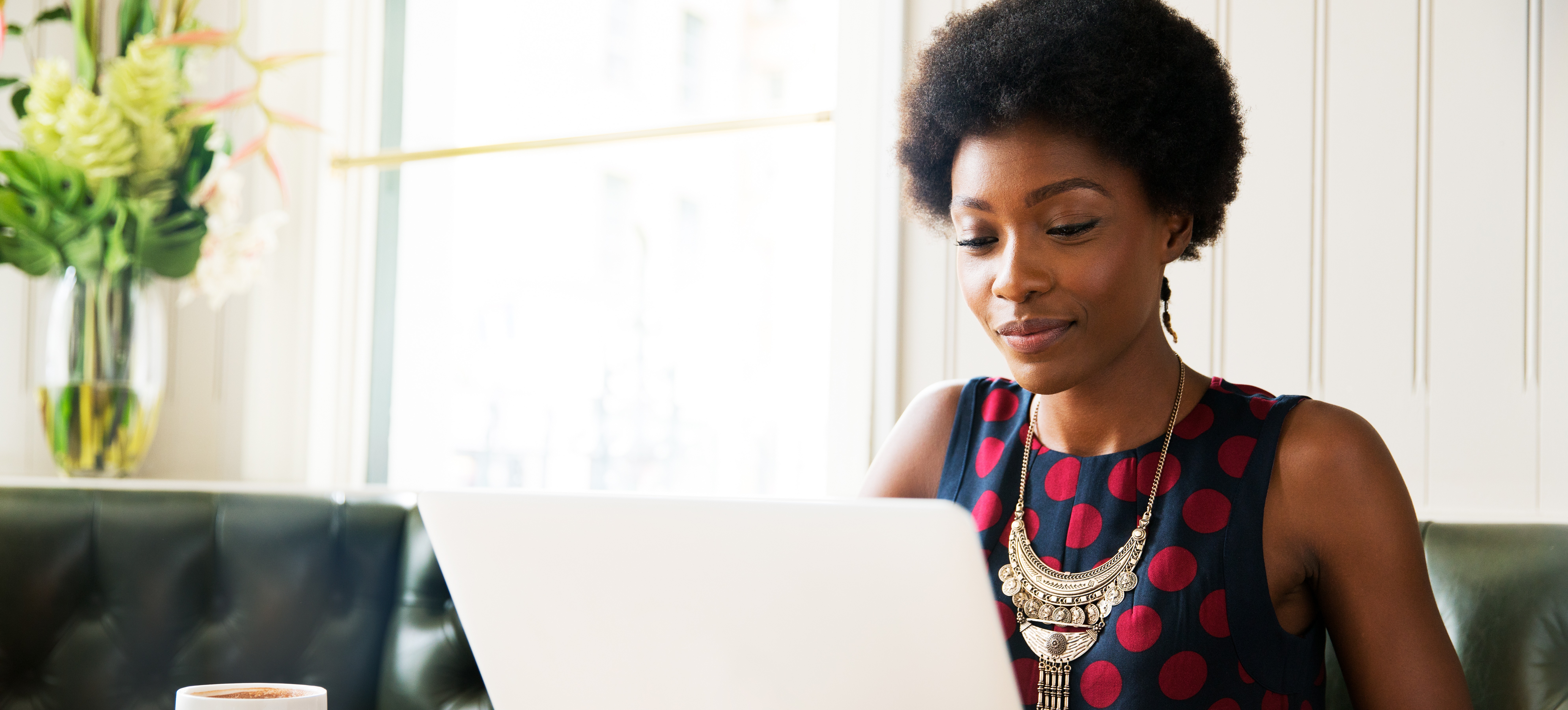 [Featured Image] Thanks to client-server architecture, a business person sitting at a table working on their laptop has a positive user experience.
