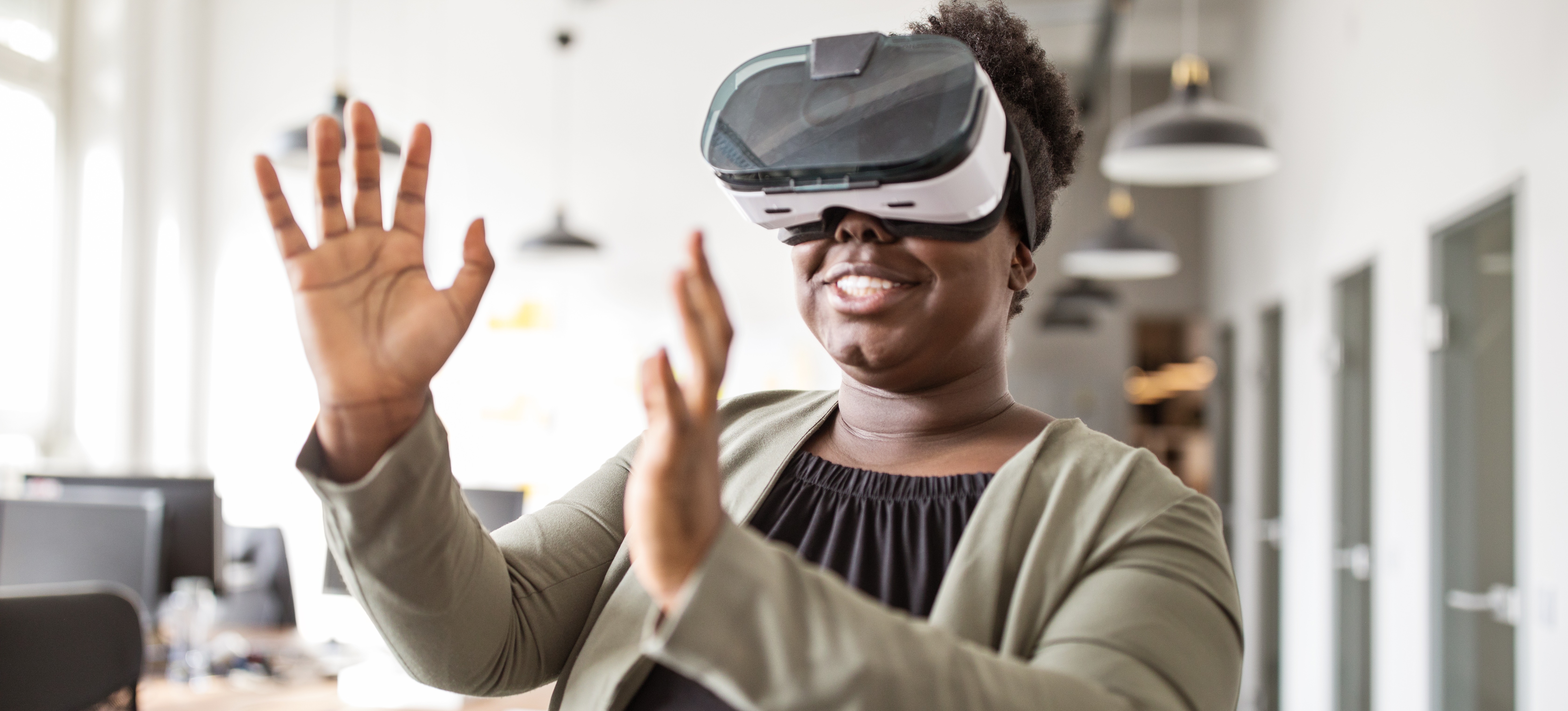 [Image en vedette] Un professionnel de la réalité étendue est assis dans un bureau et utilise un casque de réalité virtuelle (VR).