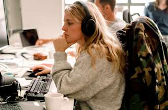 [Featured image] A person wearing a sweatshirt and headphones works with object-oriented programming languages on a desktop computer.