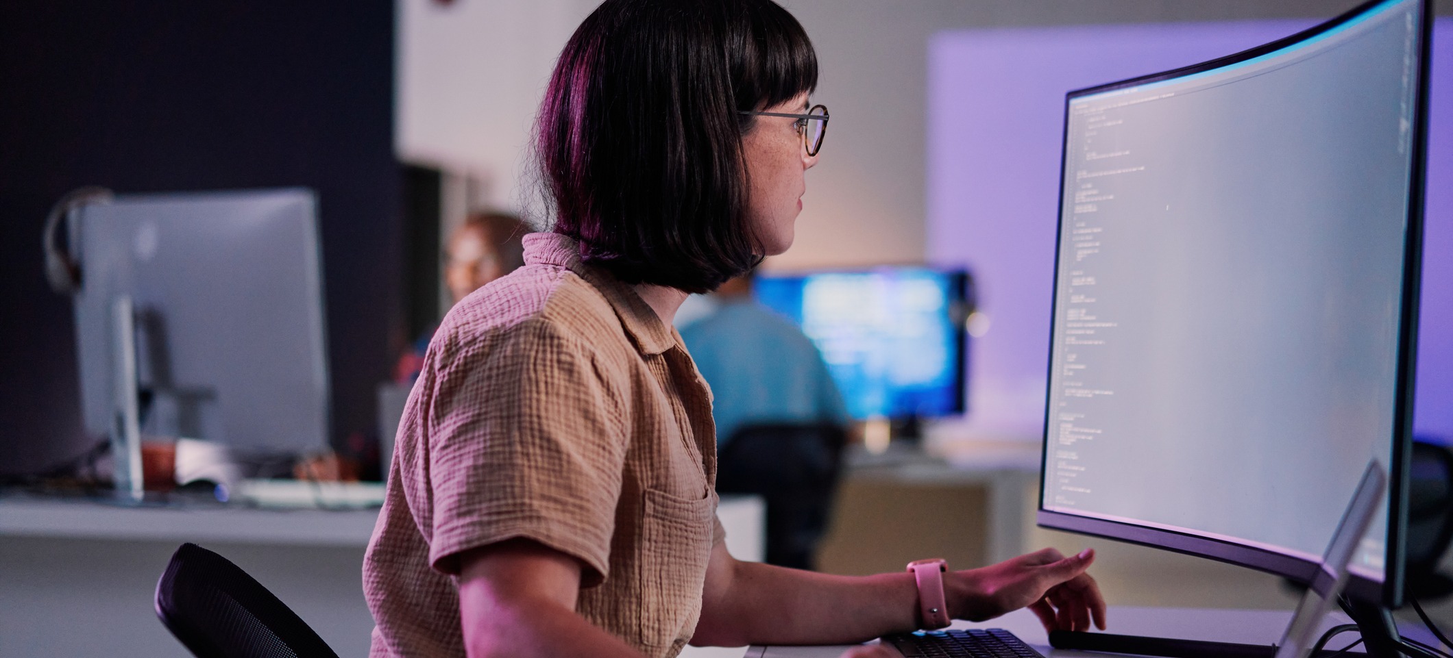 [Featured Image] A woman works on a desktop computer to form data without human supervision, otherwise known as unsupervised learning for artificial intelligence.