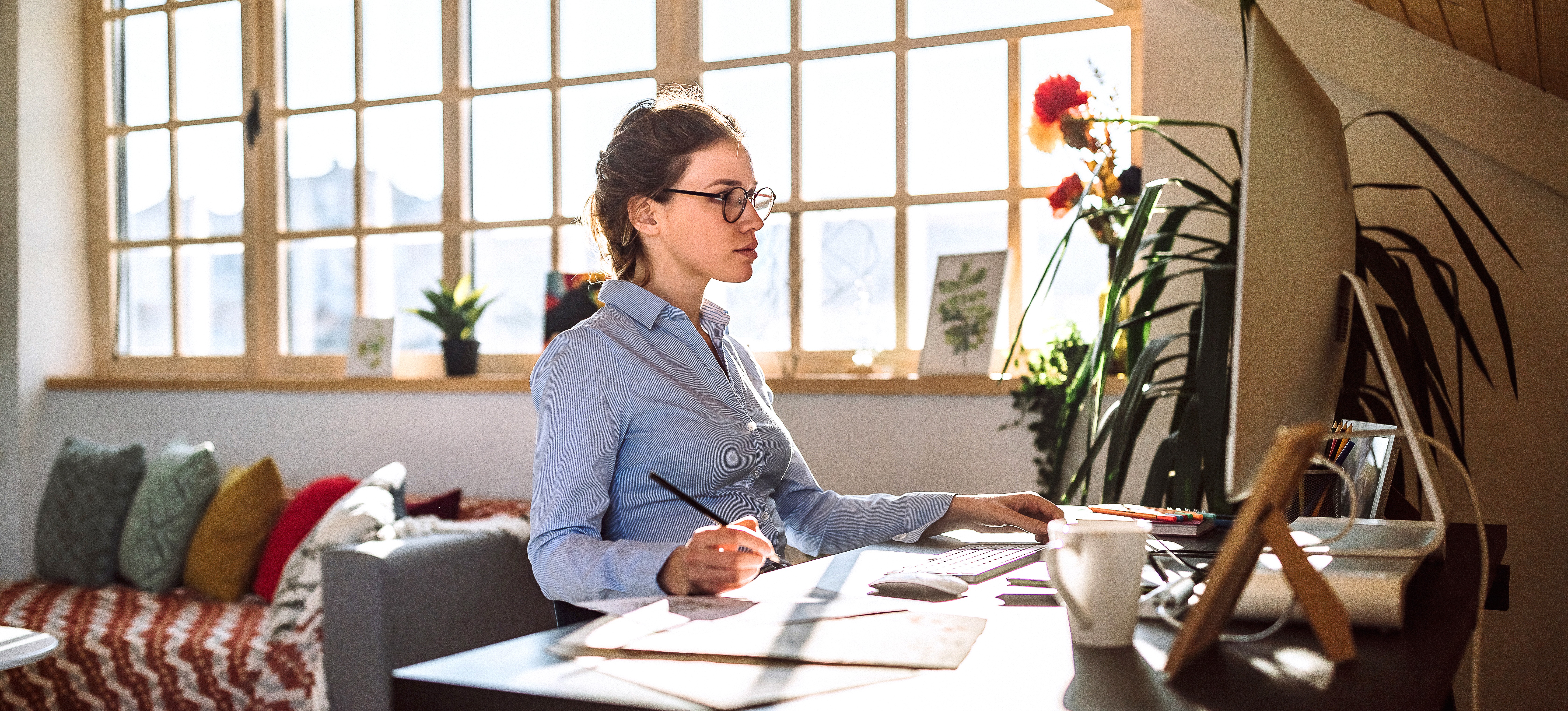 [Featured Image] A professional works at a desktop computer in a home office.