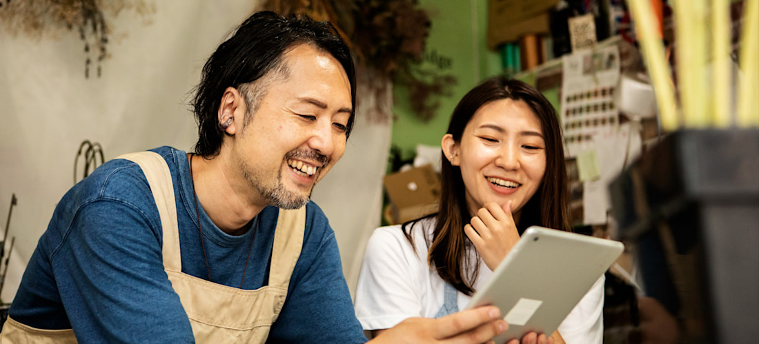 [Featured Image] A couple is excited about the benefits of AI for their small business.