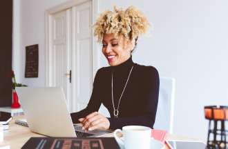 [Featured Image} A woman works on a laptop computer at a desk.